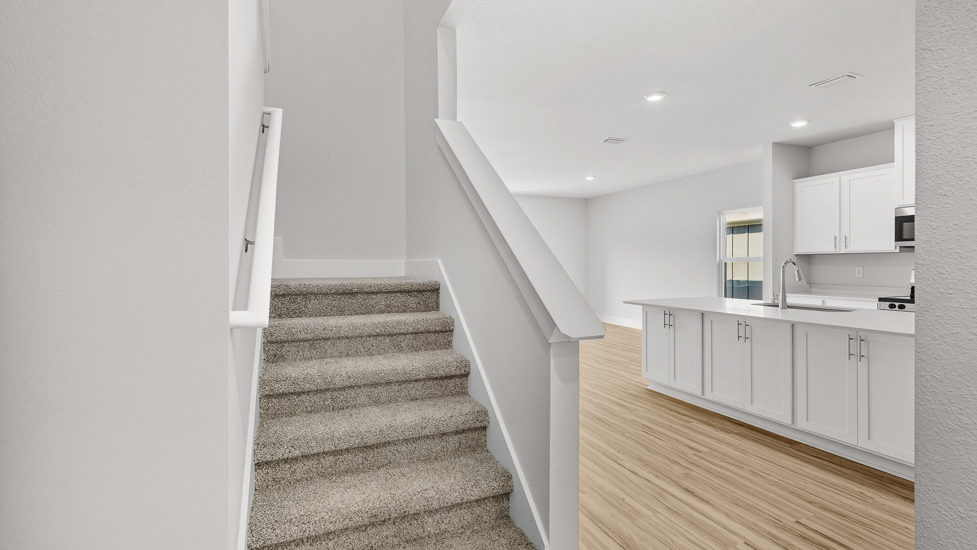 Carpeted stairs lead to the additional bedrooms on the second level