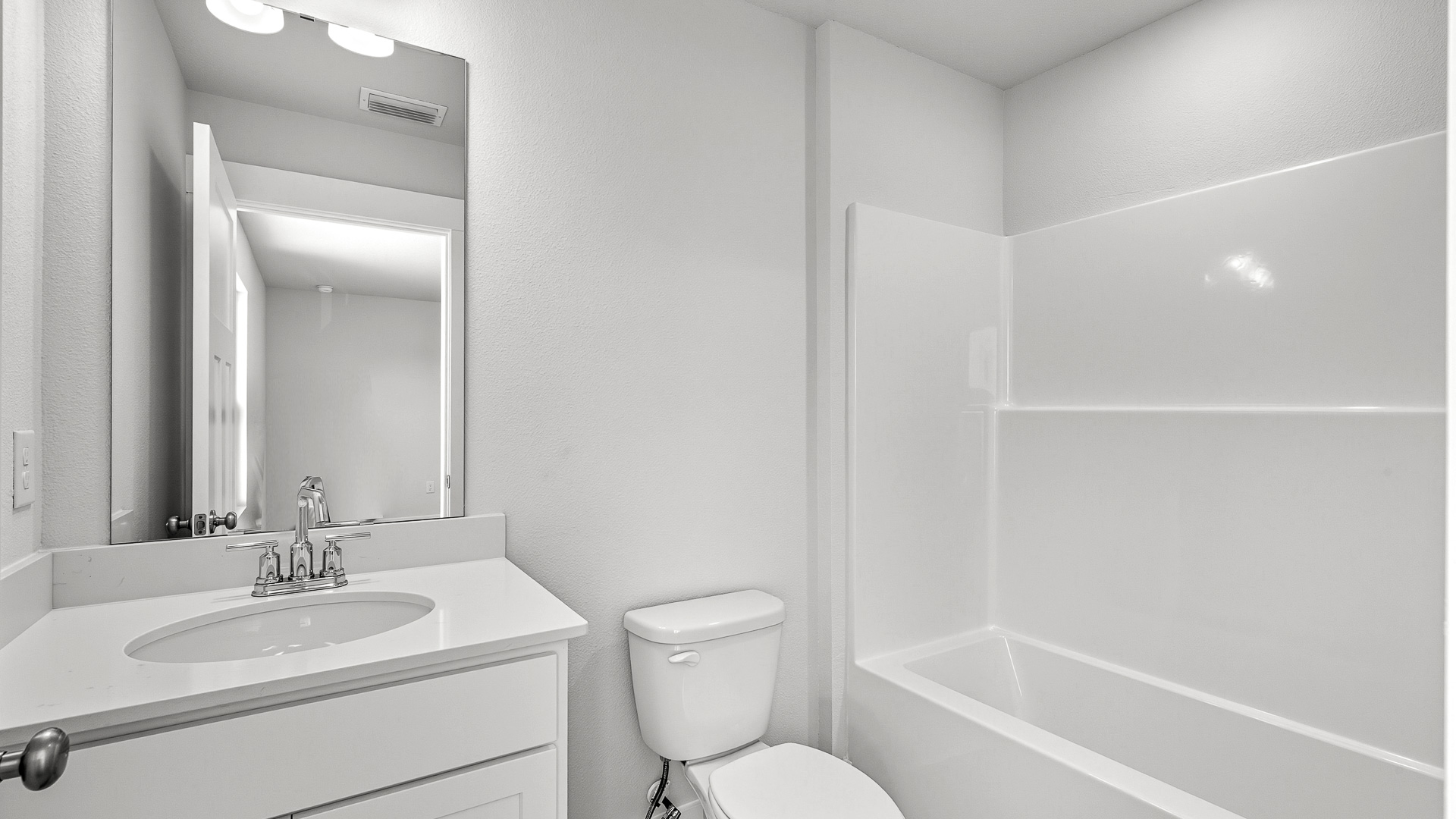 The bath in guest bedroom has a single vanity and a shower tub combination