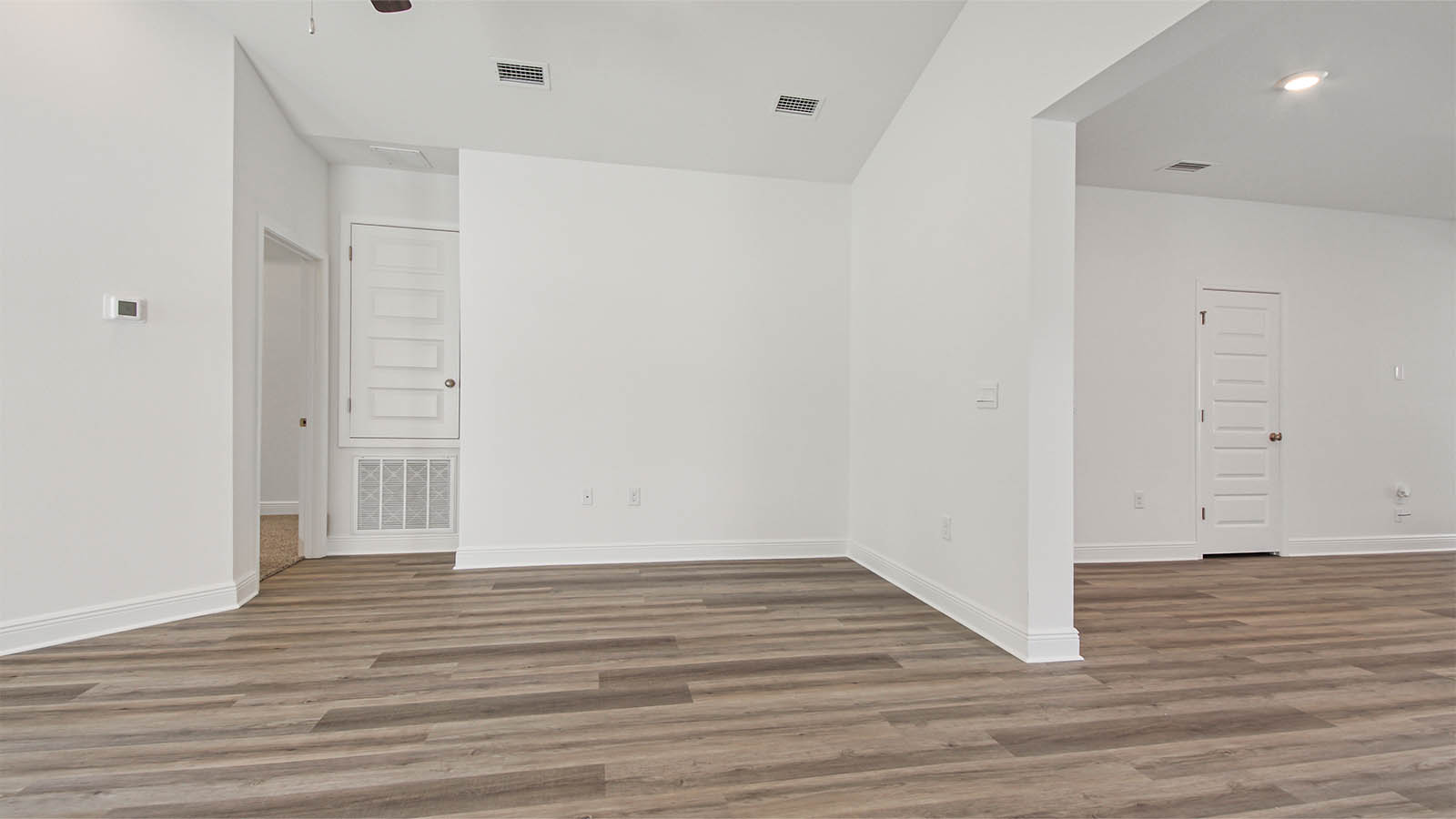 Living room that flows into the kitchen and dining area and vaulted ceilings and EVP flooring.
