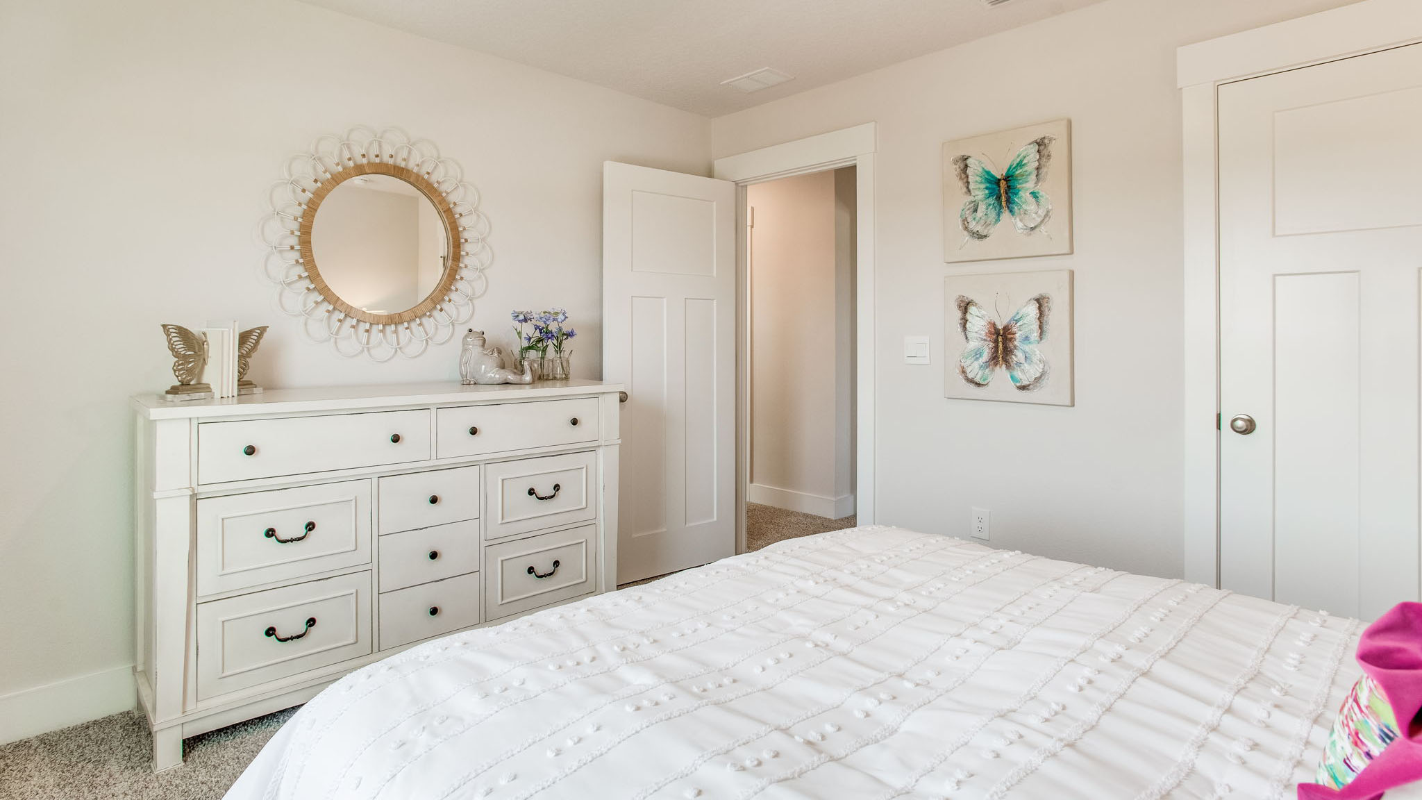 Guest bedroom on the second level is staged with a queen size bed, dresser and nightstand