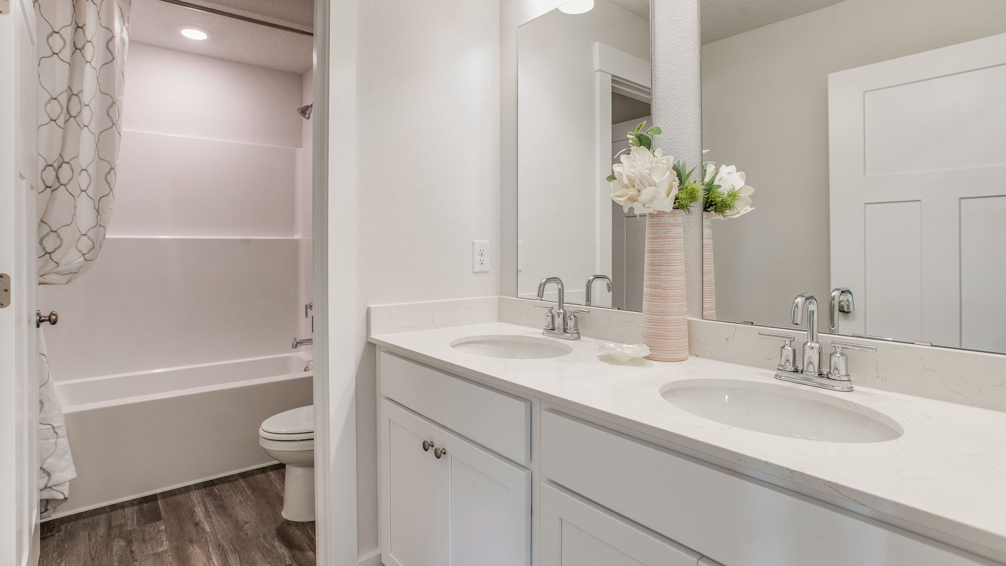 There is a shared bathroom on the second level with a dual sink vanity and separate water closet with shower tub combination