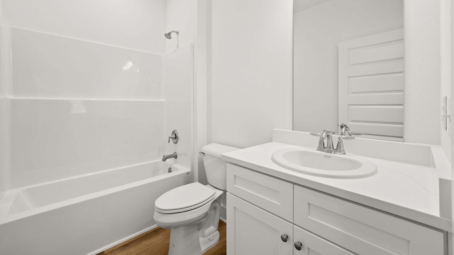There is a second full bath for guest bedrooms three and four. It has a shower tub combination and a single vanity with lower cabinetry for storage