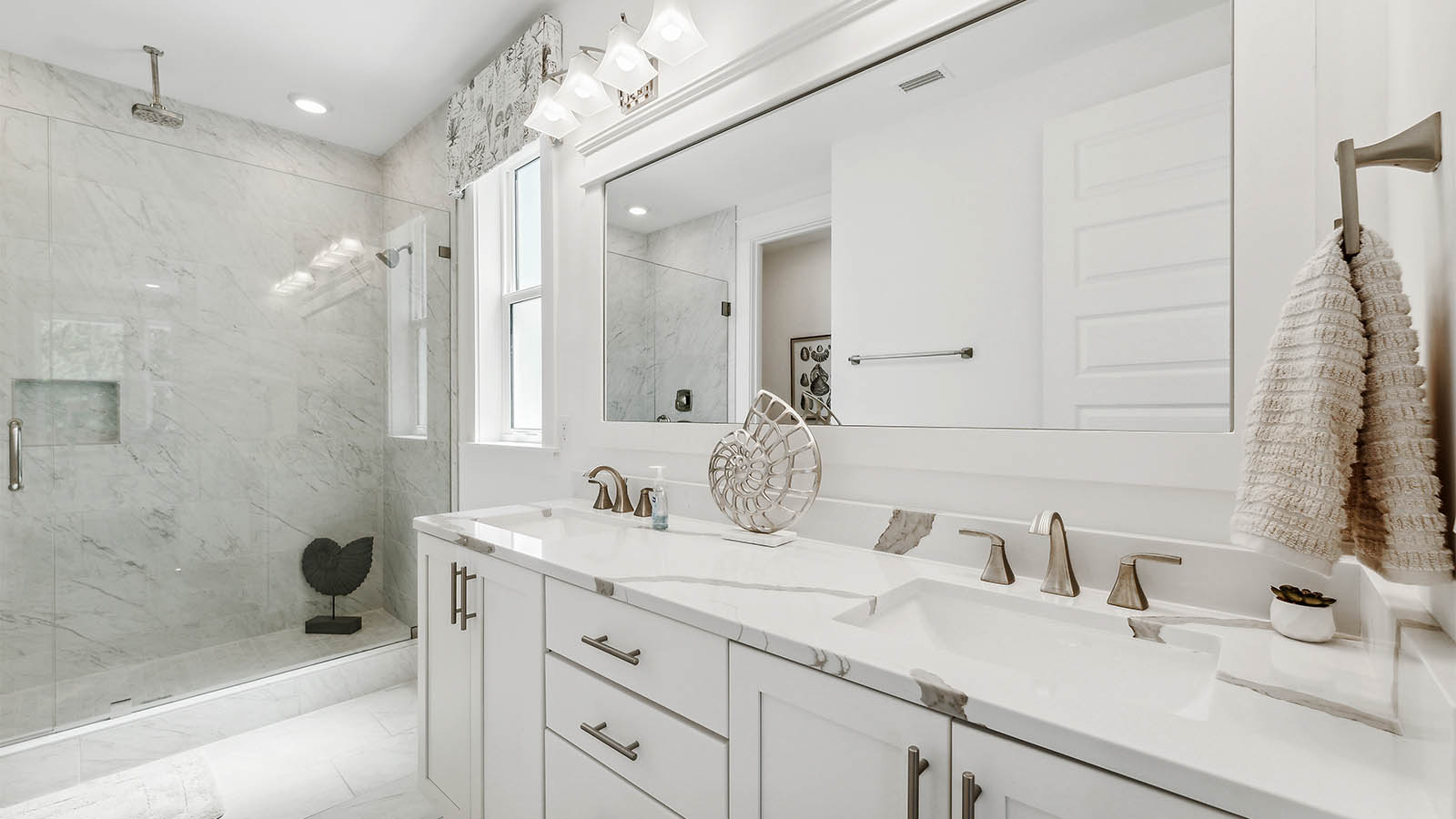 There is a full bathroom on the main level with a dual sink vanity and shower with tile and glass enclosure