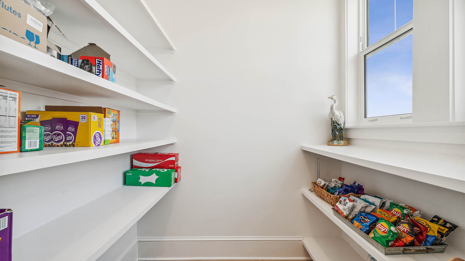 There is a spacious pantry off the kitchen with wood shelves