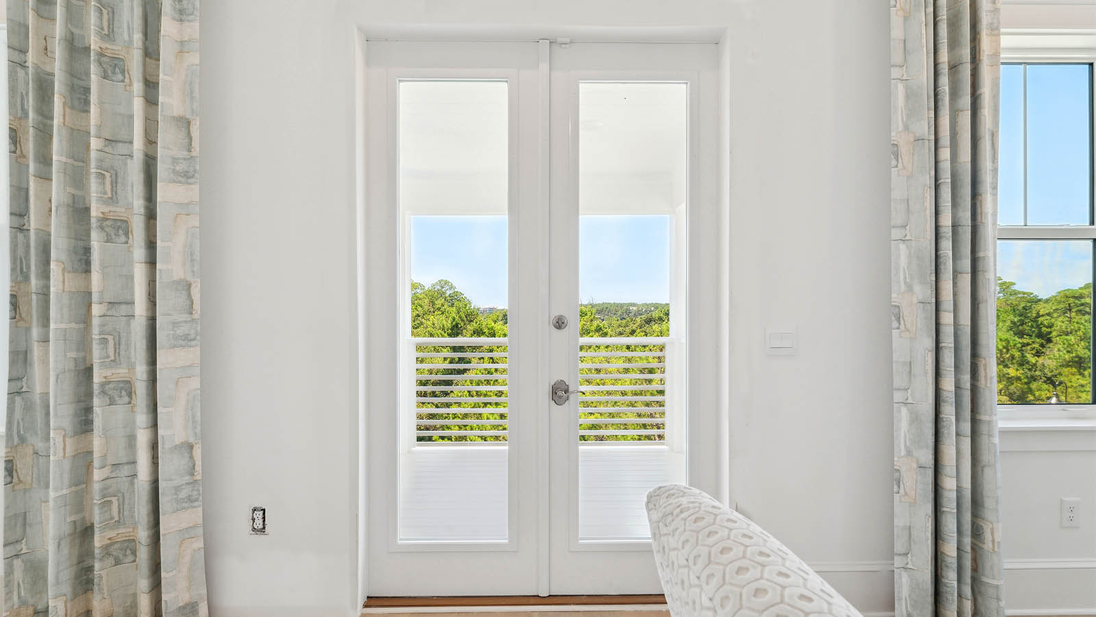 There are double doors leading to the private balcony on the third level