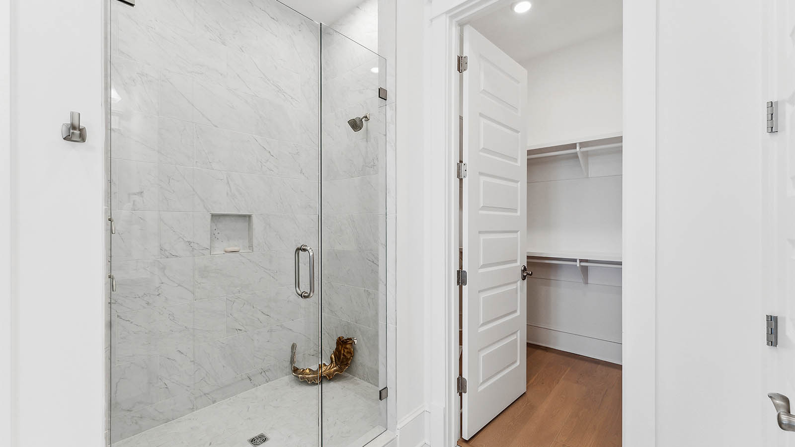 The primary bath has large closet with wood shelving