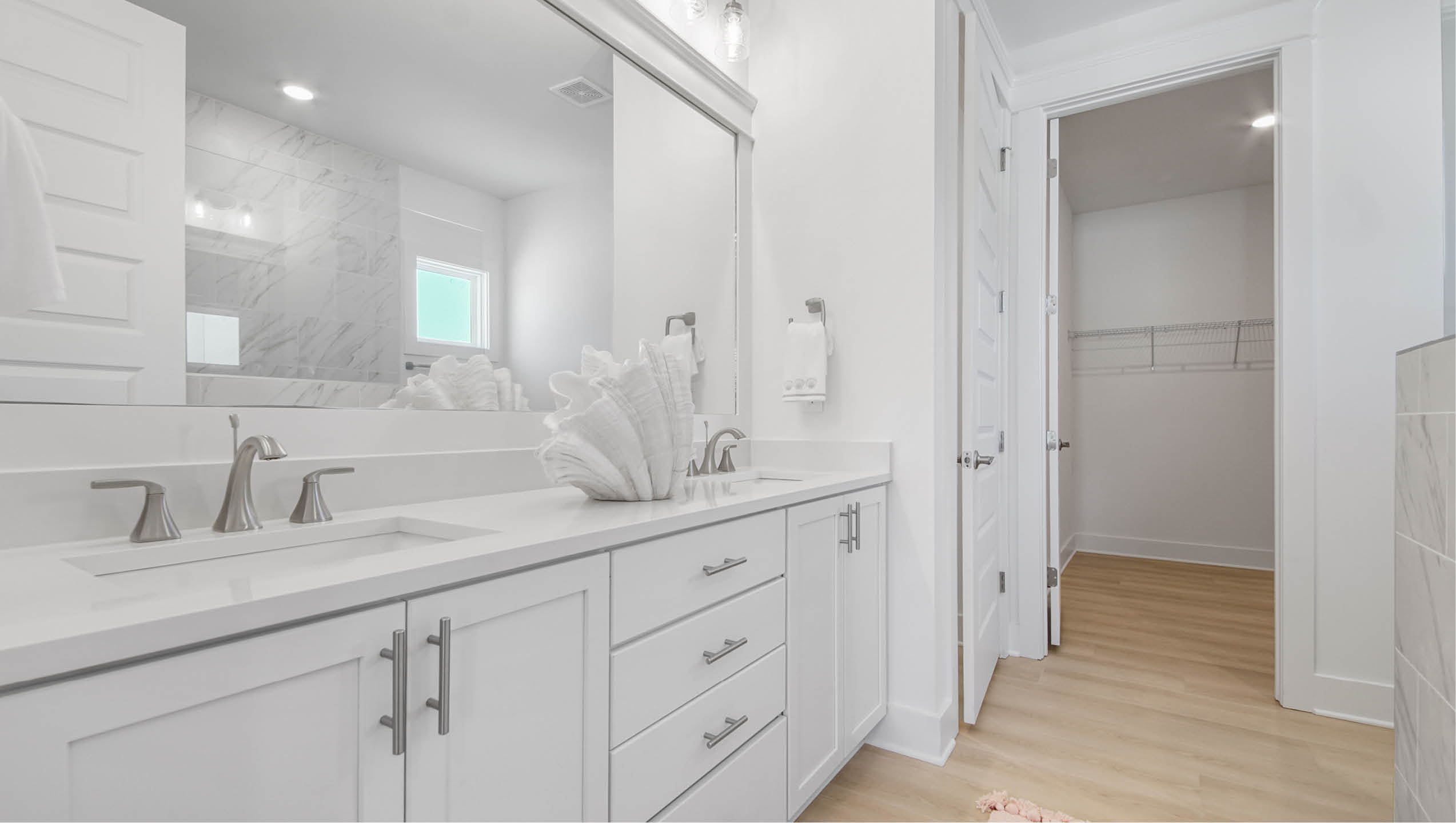 Primary bathroom with quartz countertop dual sink vanity and lower cabinetry and drawers