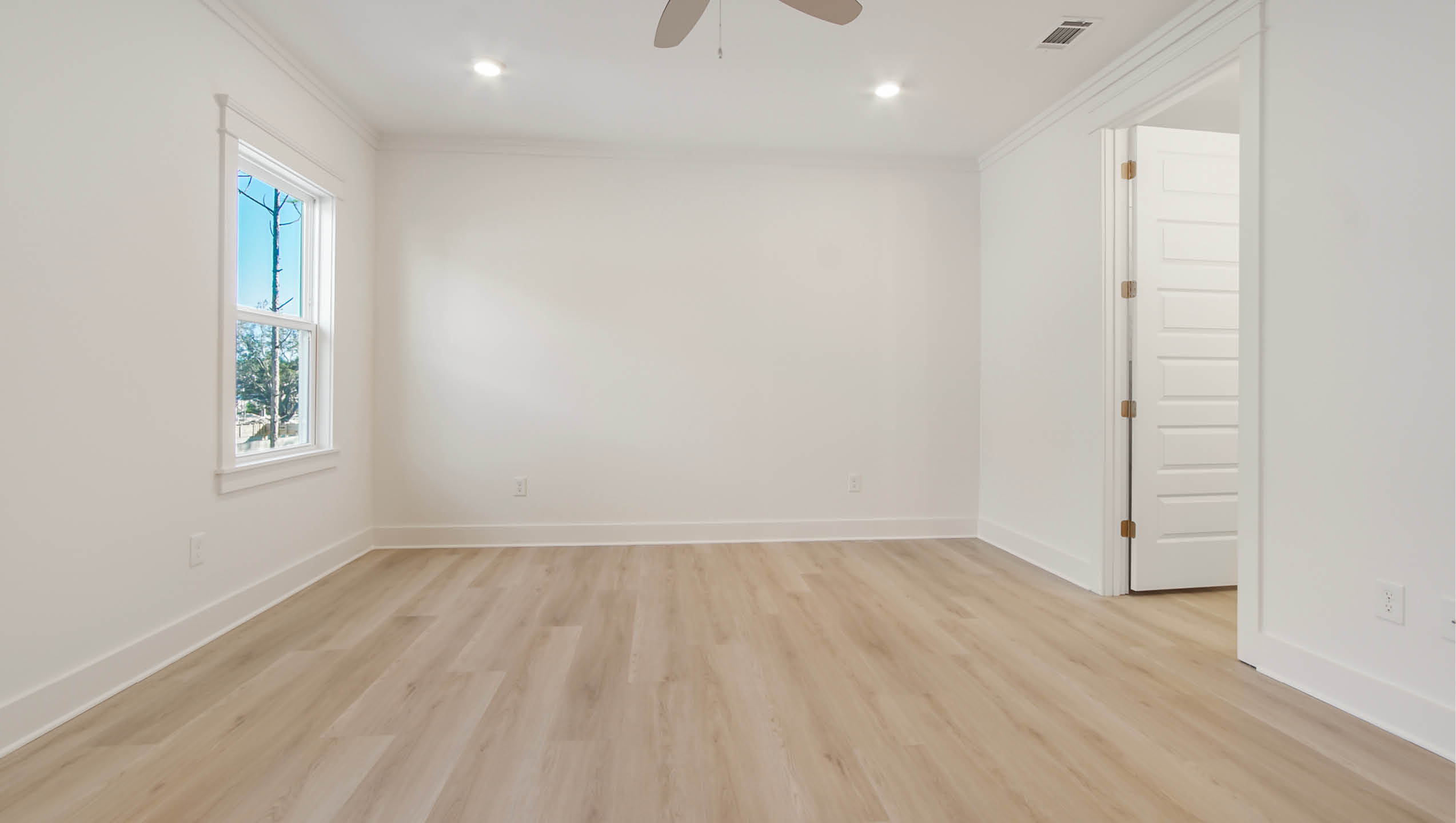 Primary bedroom is spacious and has abundant natural lighting
