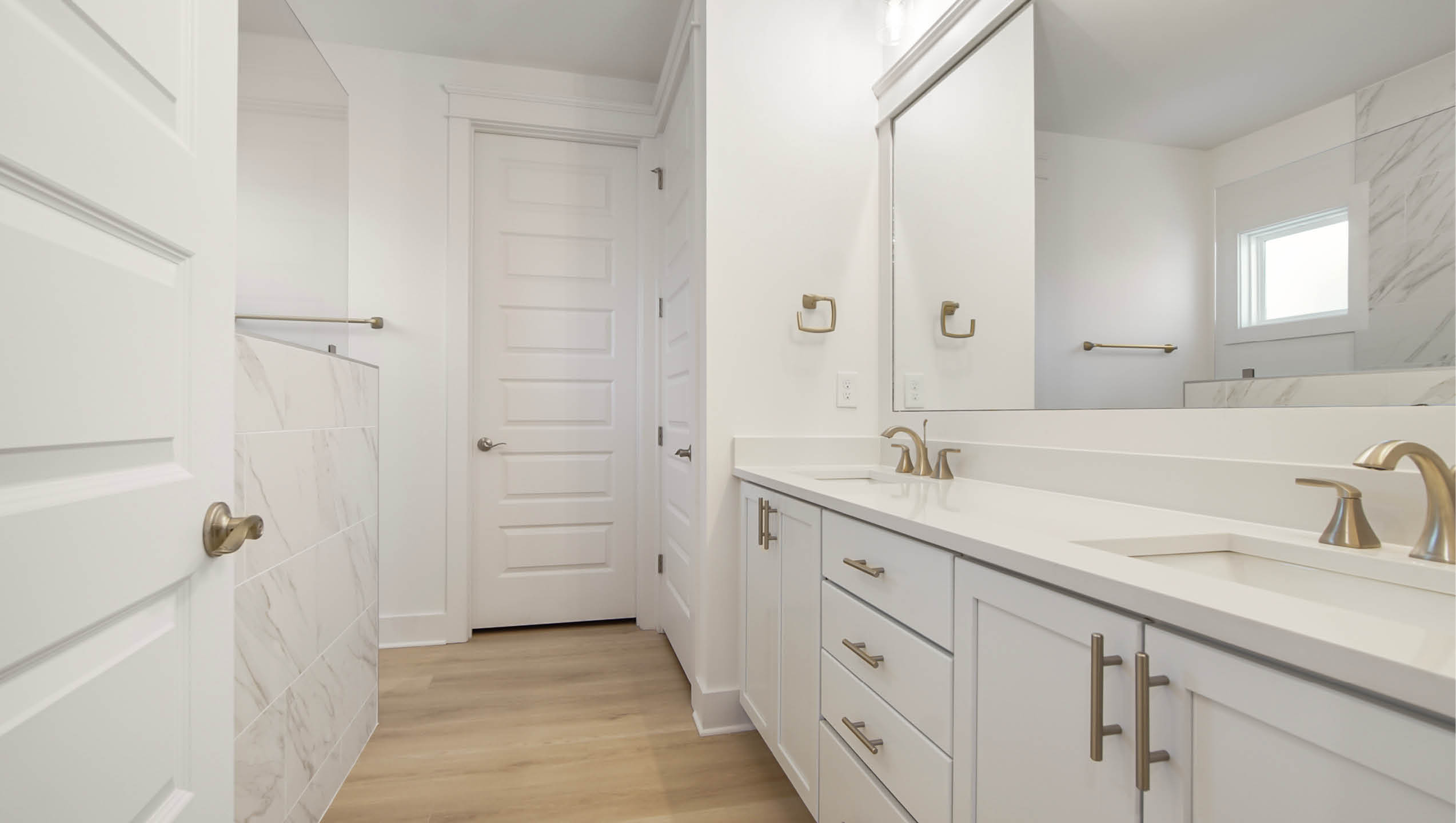 Primary bathroom with dual sink vanity and quartz countertop with lower cabinetry