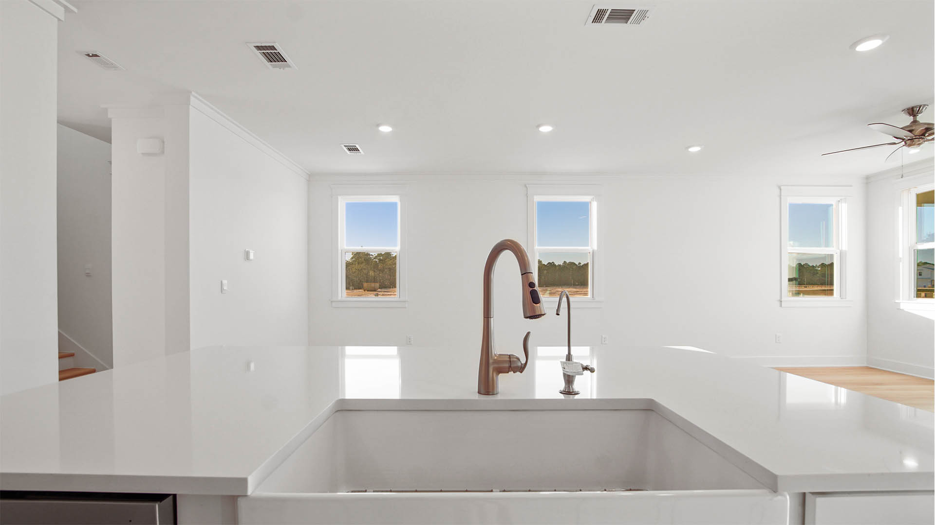 Kitchen overlooking the great room with quartz countertop and sink with pull down faucet and water filtration tap ready for hookup