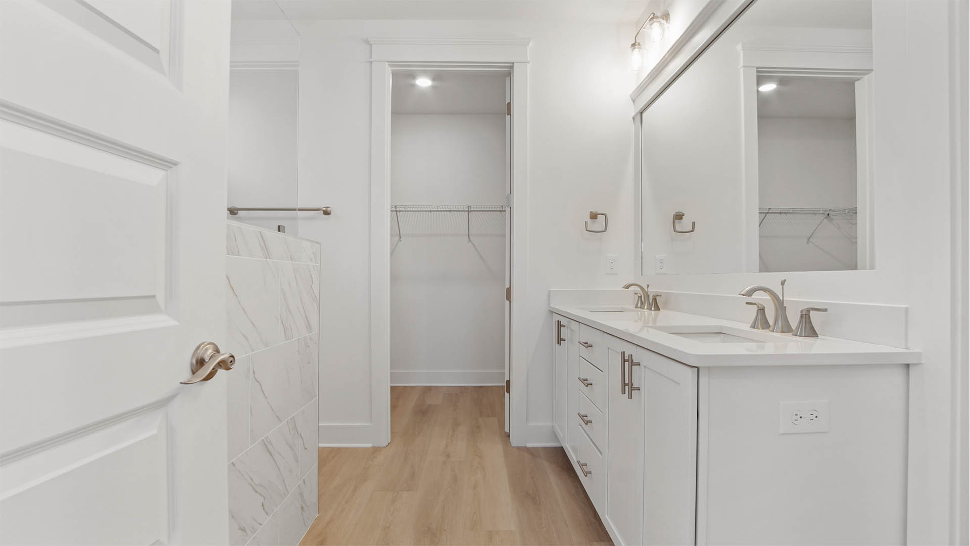 Primary bathroom with large vanity with dual sinks and quartz countertops