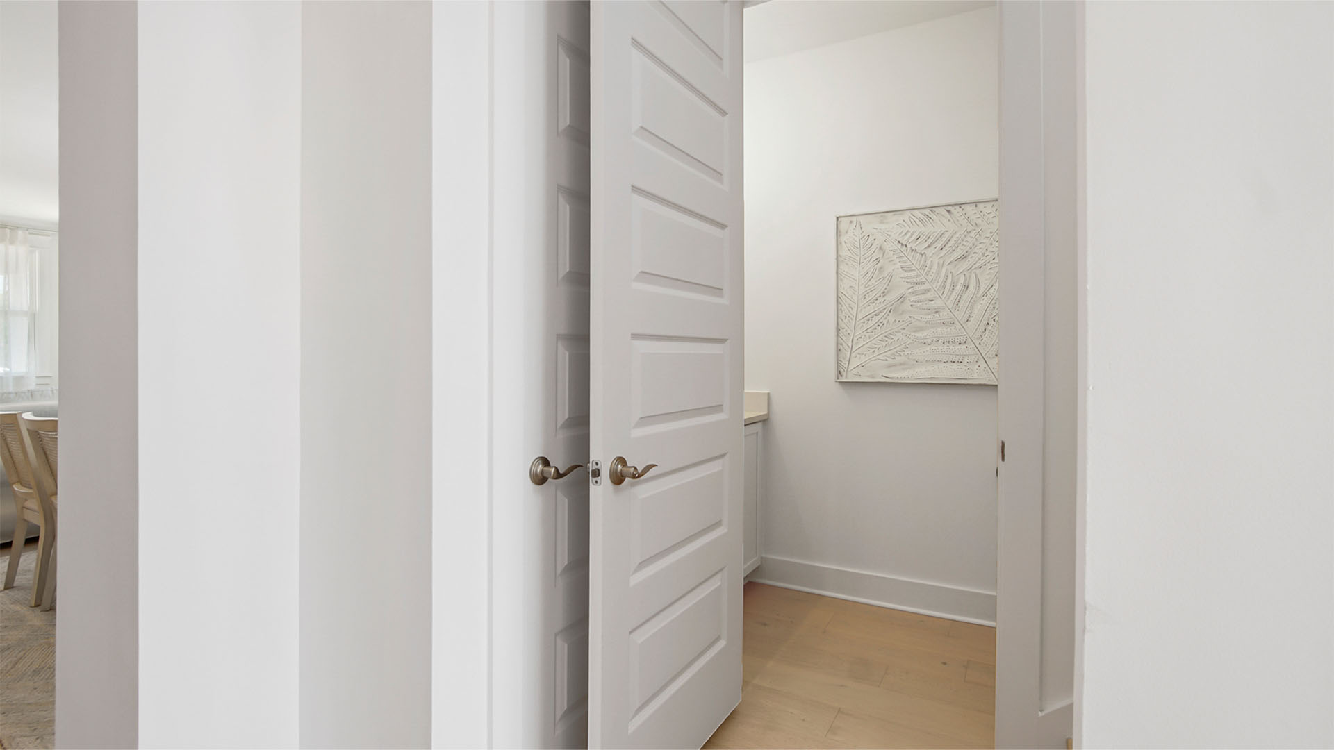 Powder room entrance in hallway next to stairs.