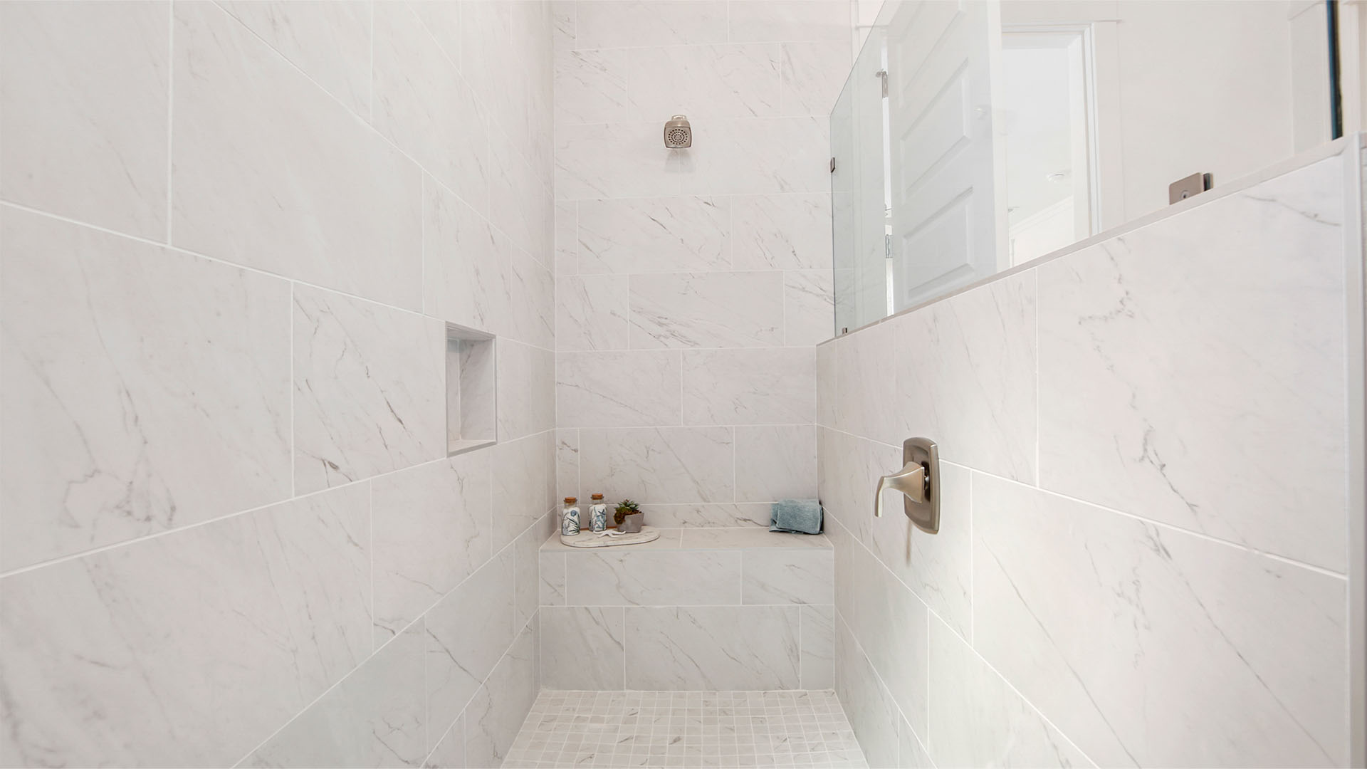 Large walk-in tile shower with bench.