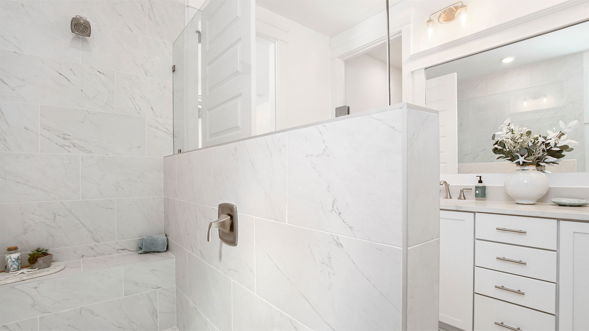 Large walk-in tile shower with bench.