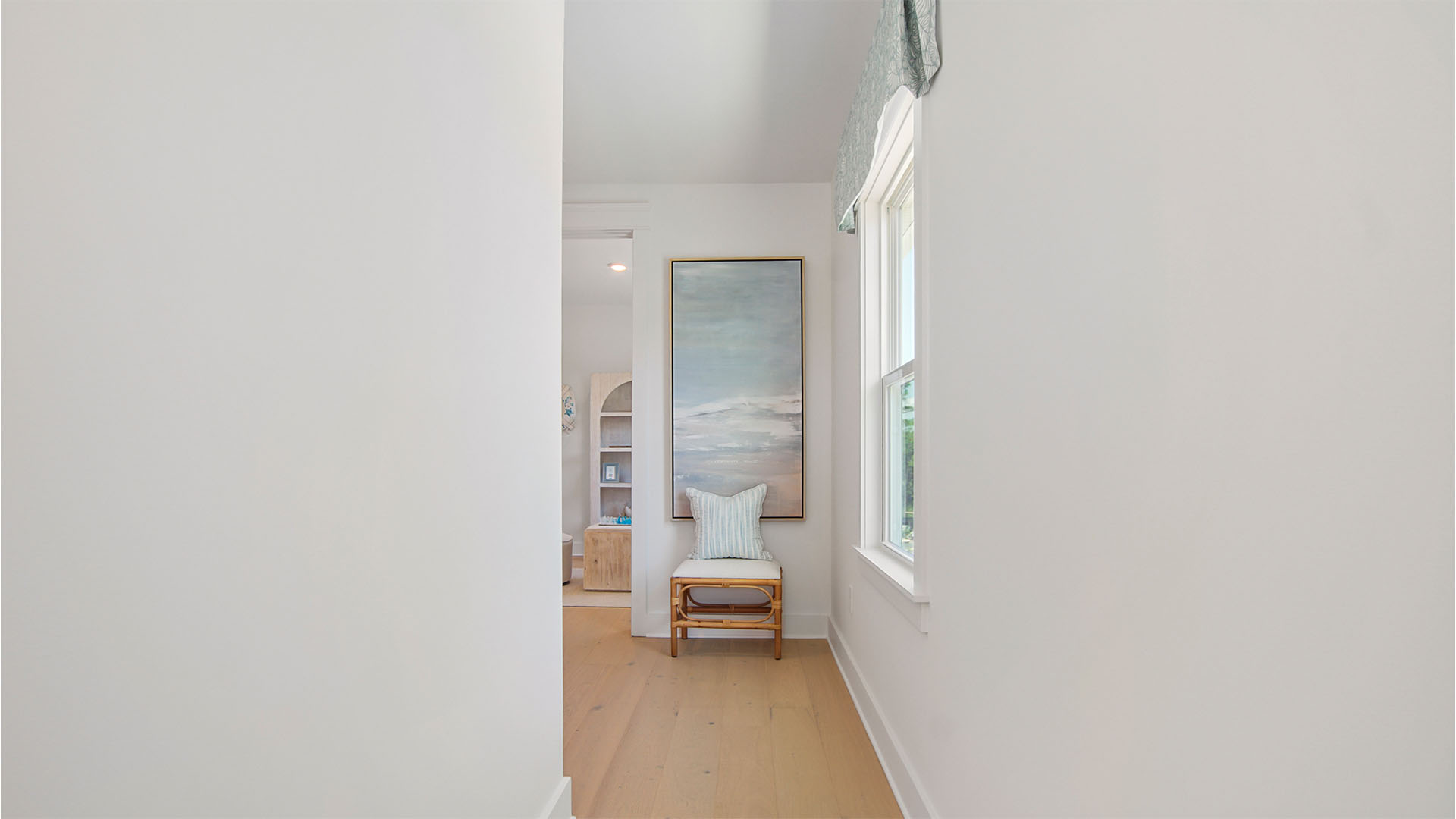 Upstairs landing with window and wood flooring.