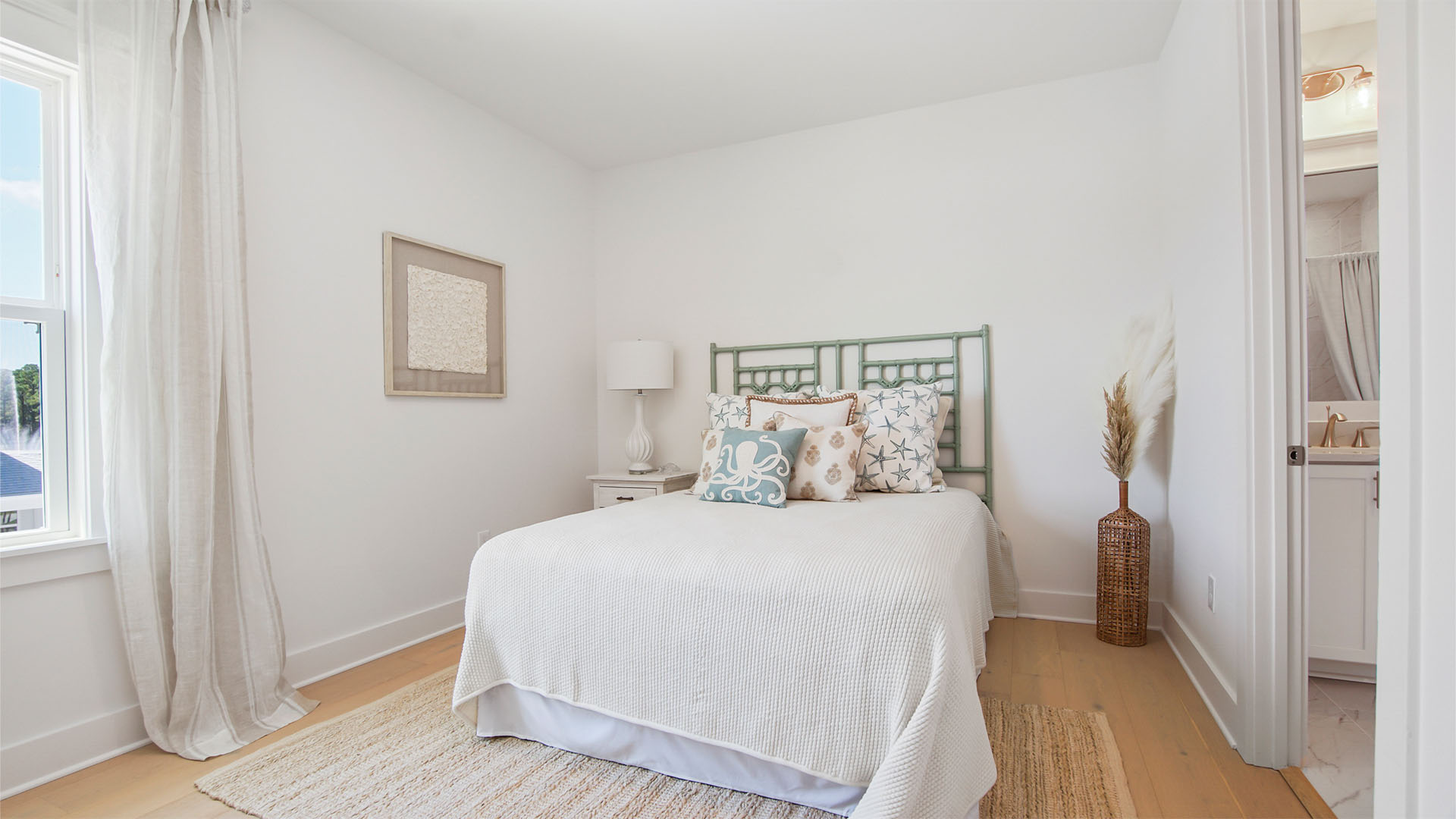 Bedroom two with wood flooring and window and bathroom entrance.