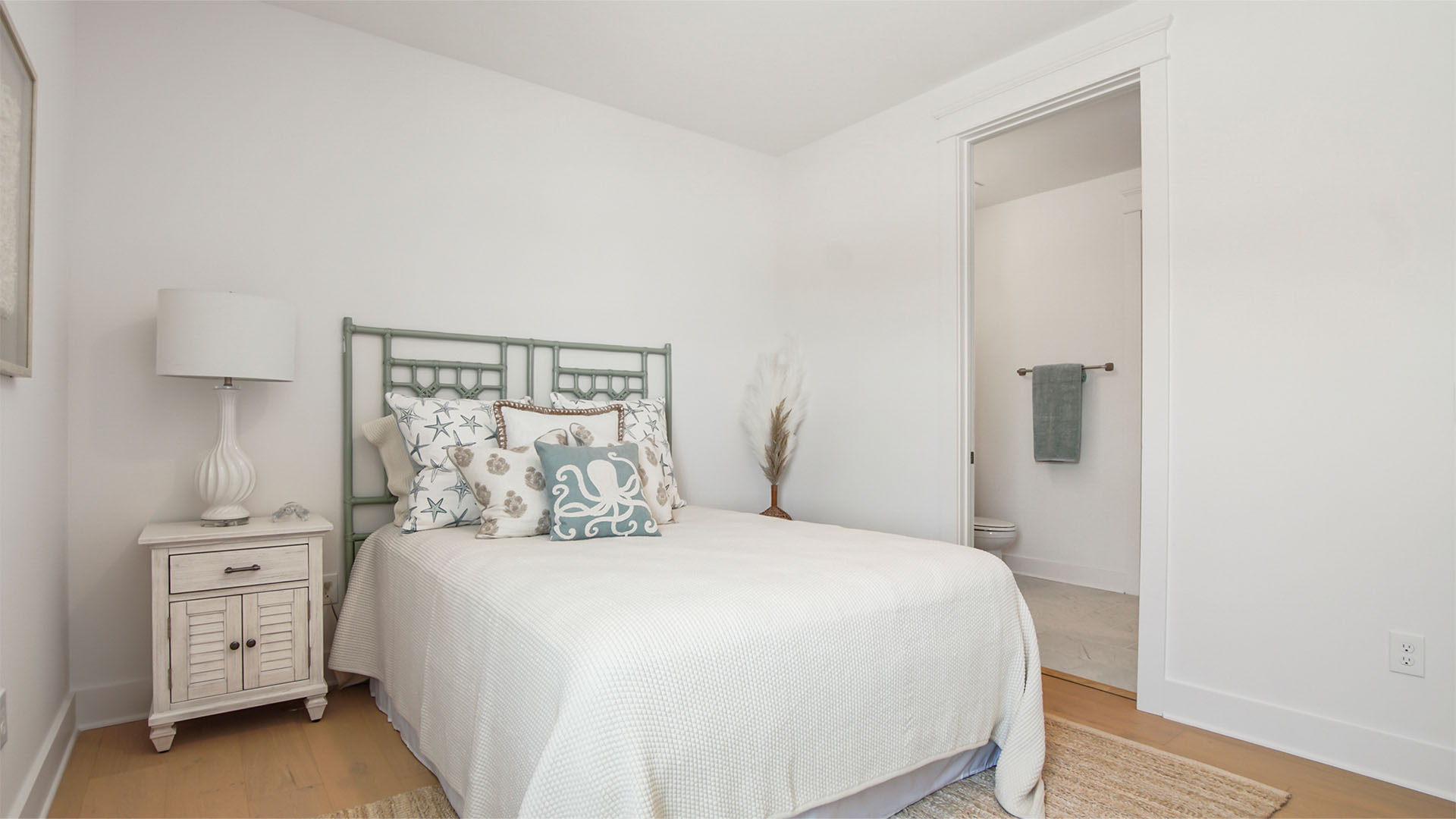 Bedroom two with wood flooring and bathroom entrance.