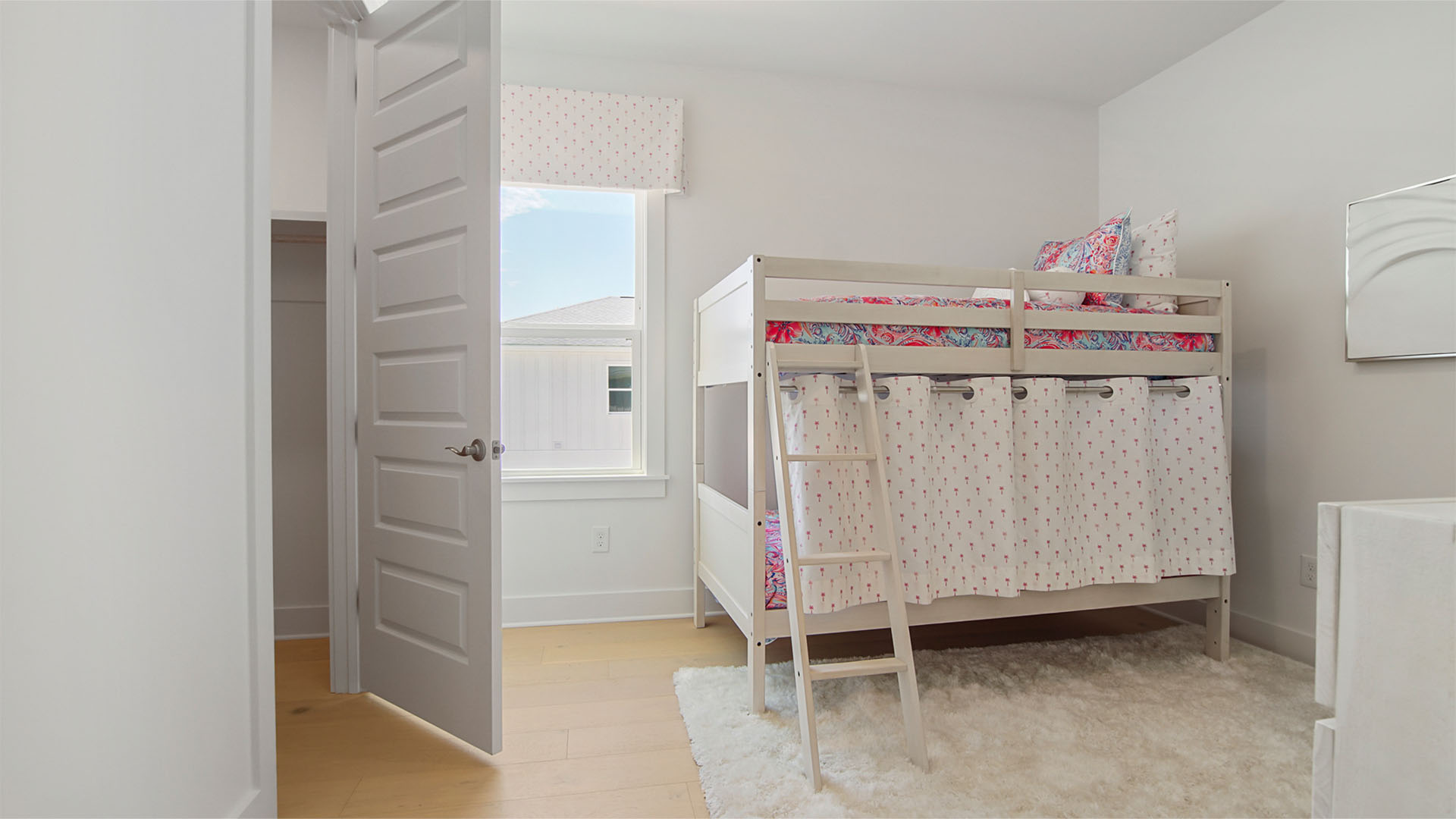 Bedroom three with wood flooring and walk-in closet and window.