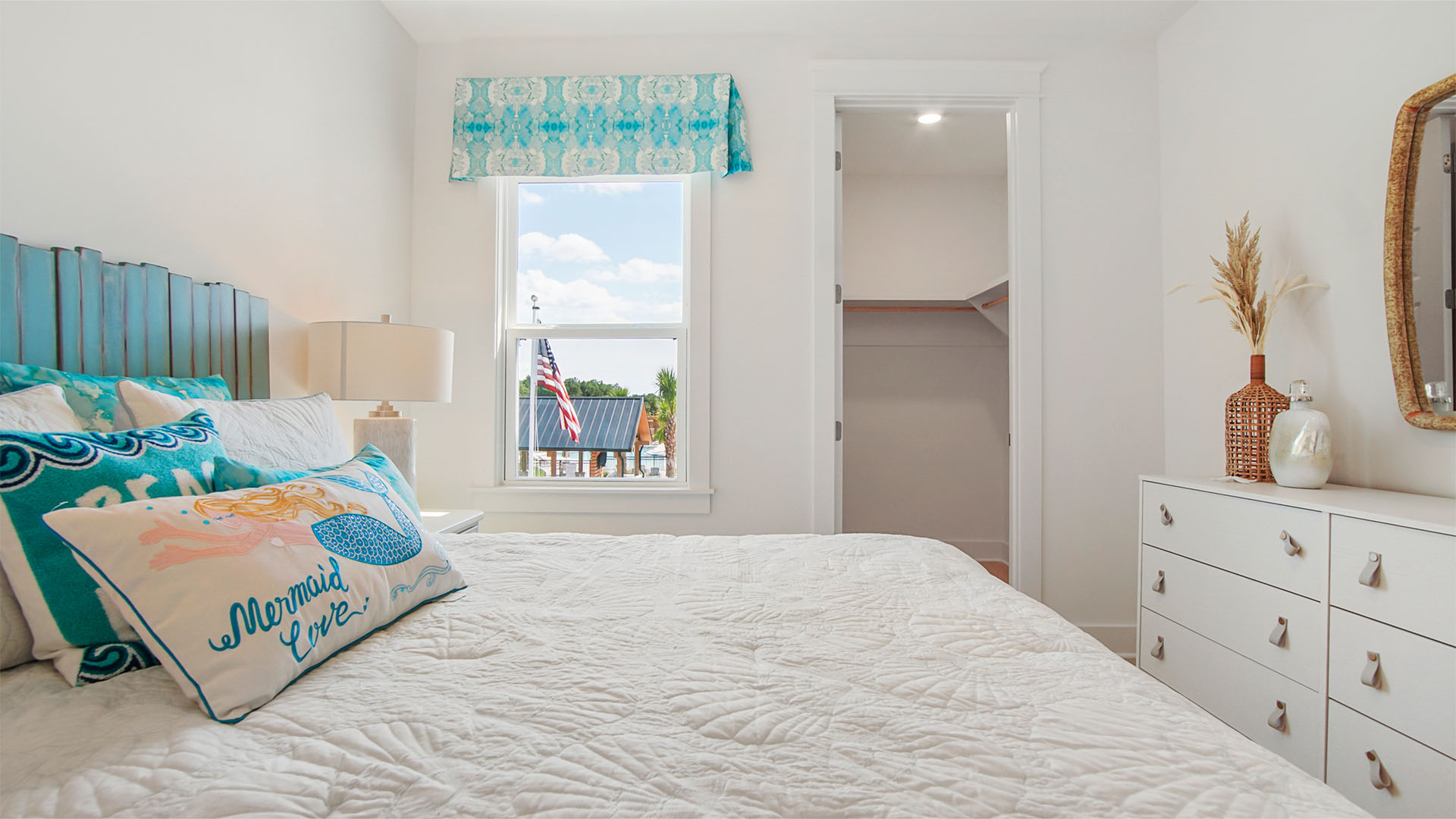 Bedroom four with walk-in closet and window and wood flooring.