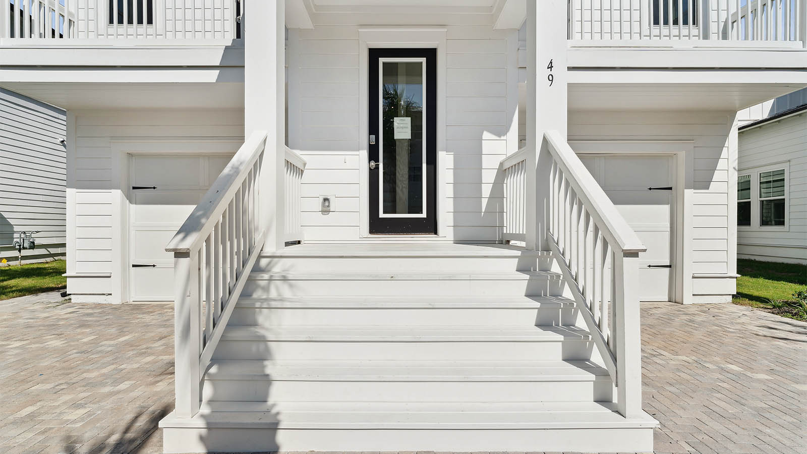 The stairs leading to the front entrance add to the charm of this beautiful coastal home