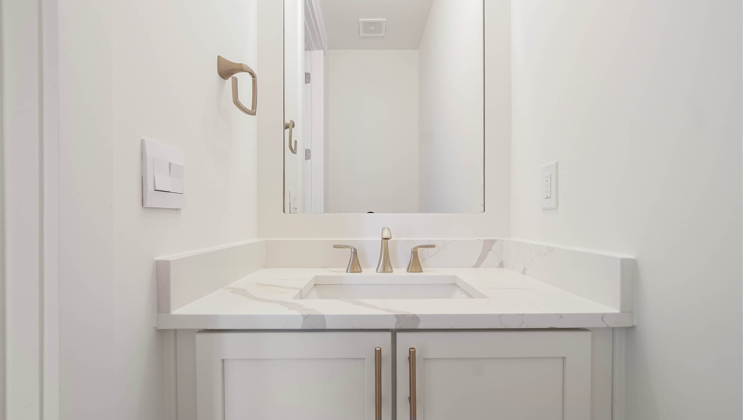Powder room with quartz counters and lower cabinetry with vanity