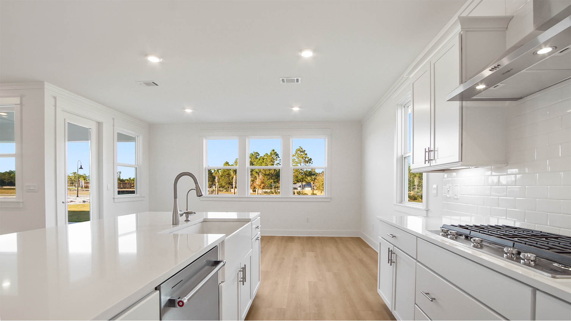 Kitchen opens to the dining area and has a gas cooktop stove with hood vent