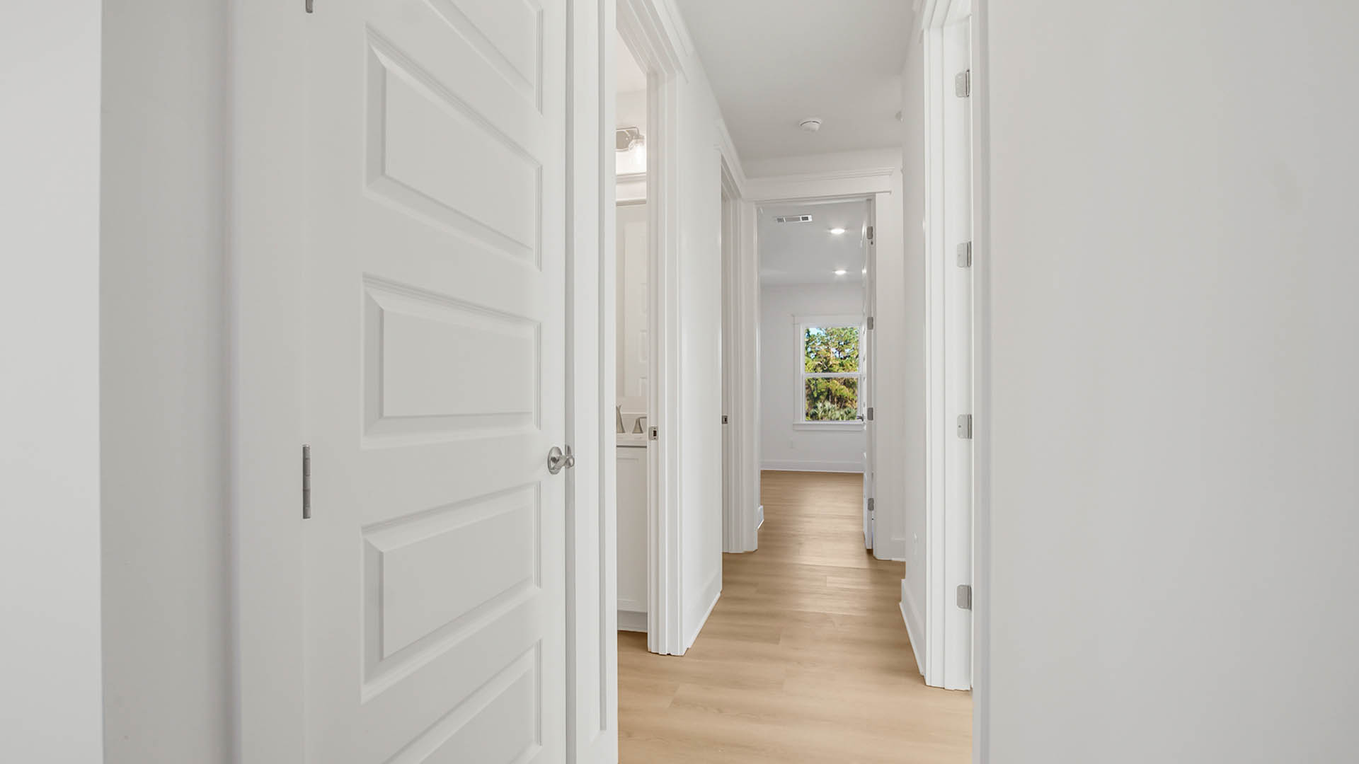 Hallway leading to shared bathroom and bedroom one