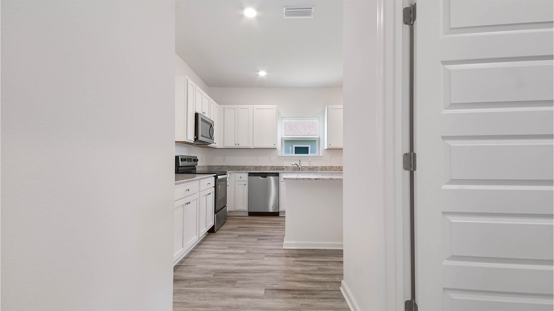 Hallway into kitchen with doorway to laundry room.