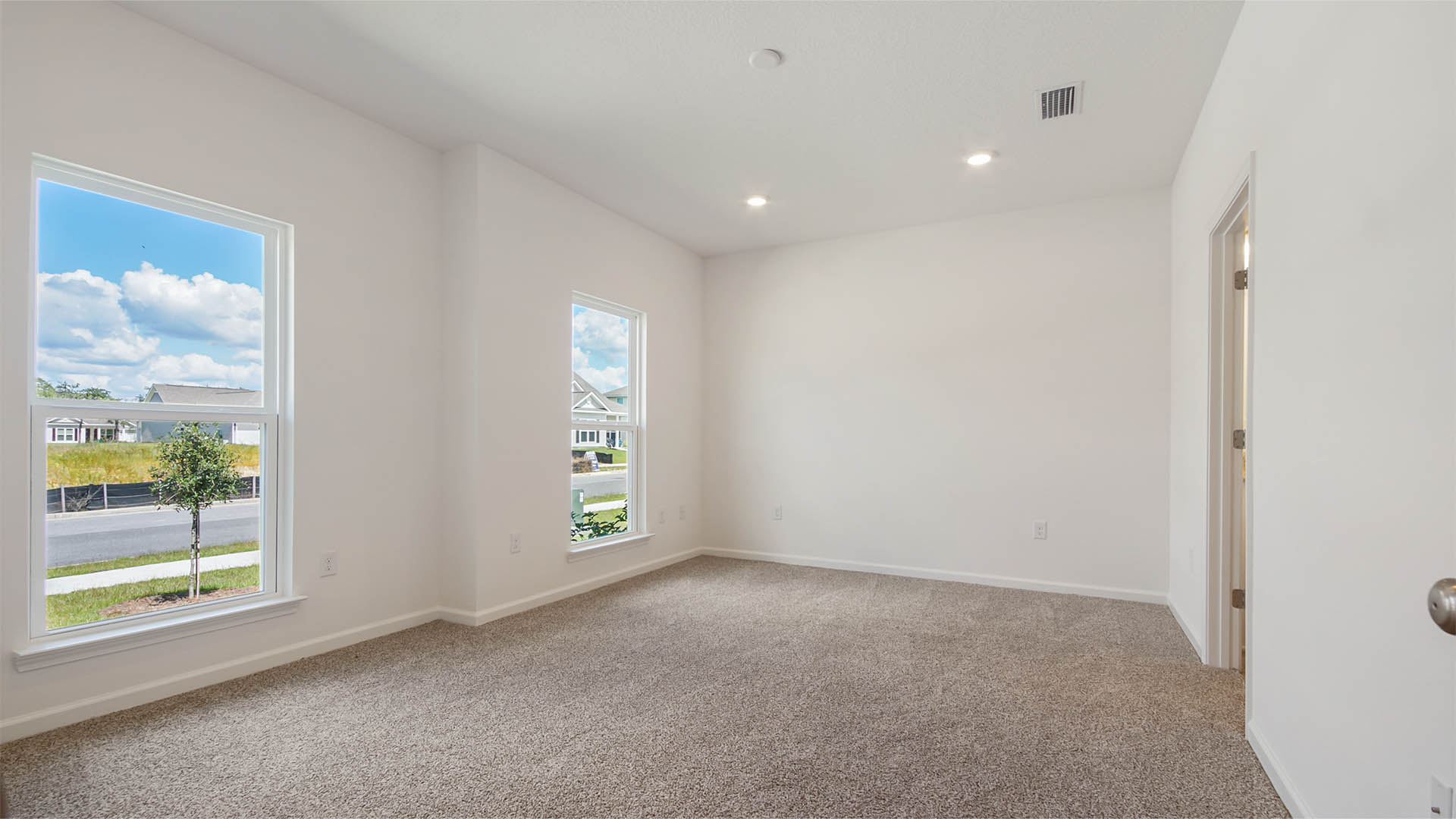 The primary bedroom multiple windows allowing for natural light