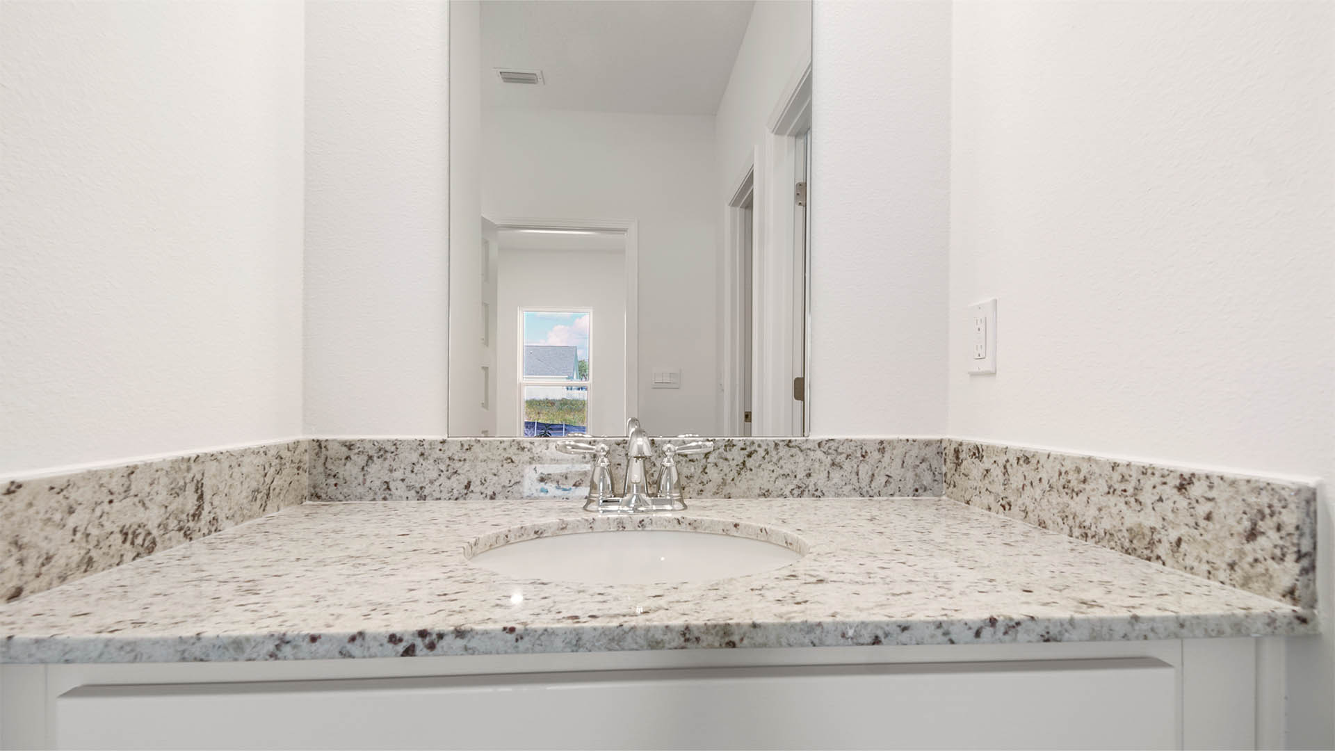 The two single vanities in the primary bathroom have granite countertops