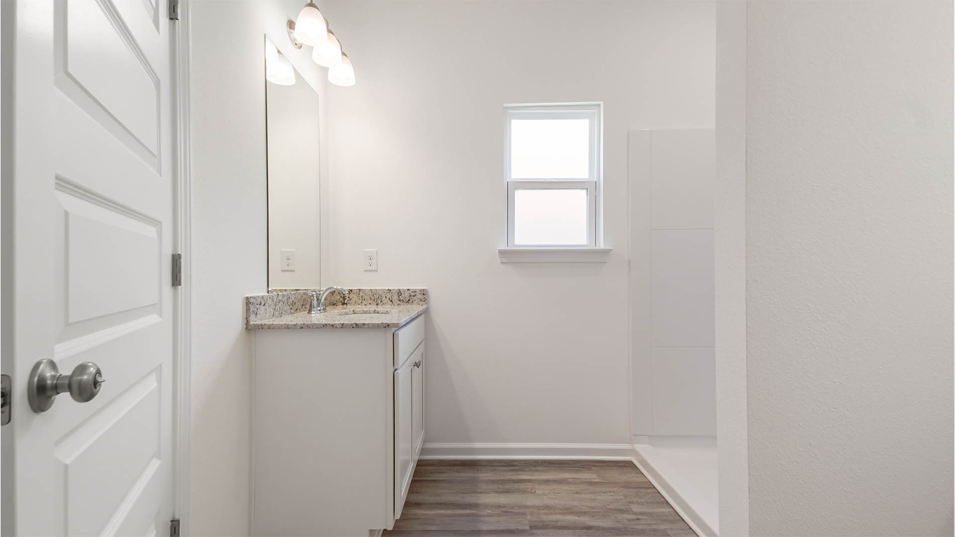 Single vanity in the primary bathroom across from the shower