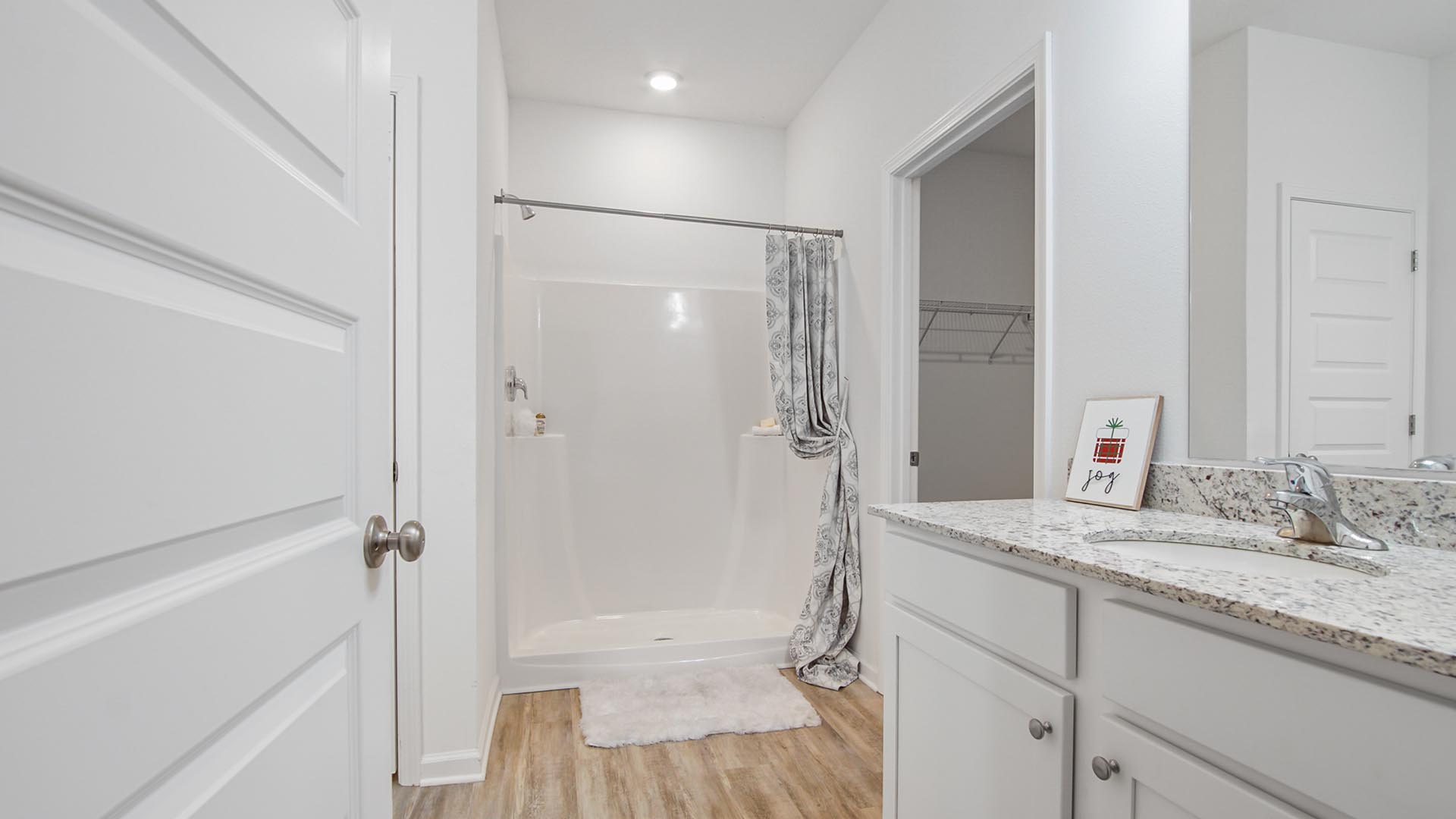 The Primary bathroom has EVP flooring and granite countertops