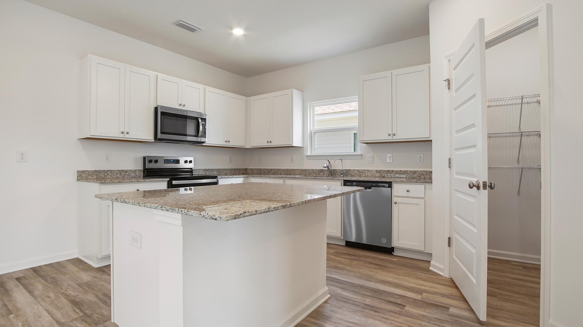 The kitchen features a center island with granite countertops