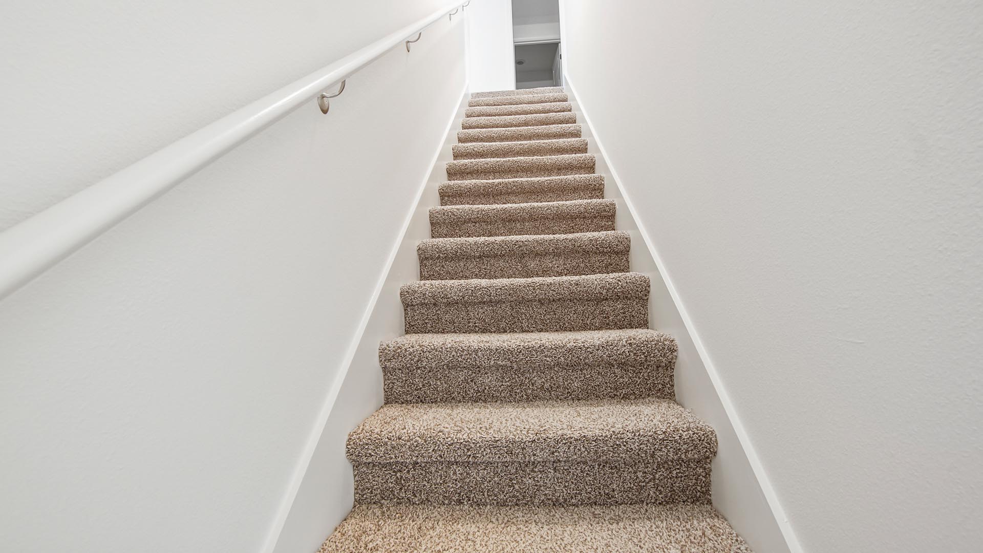Stairs leading to the two additional bedrooms have carpet