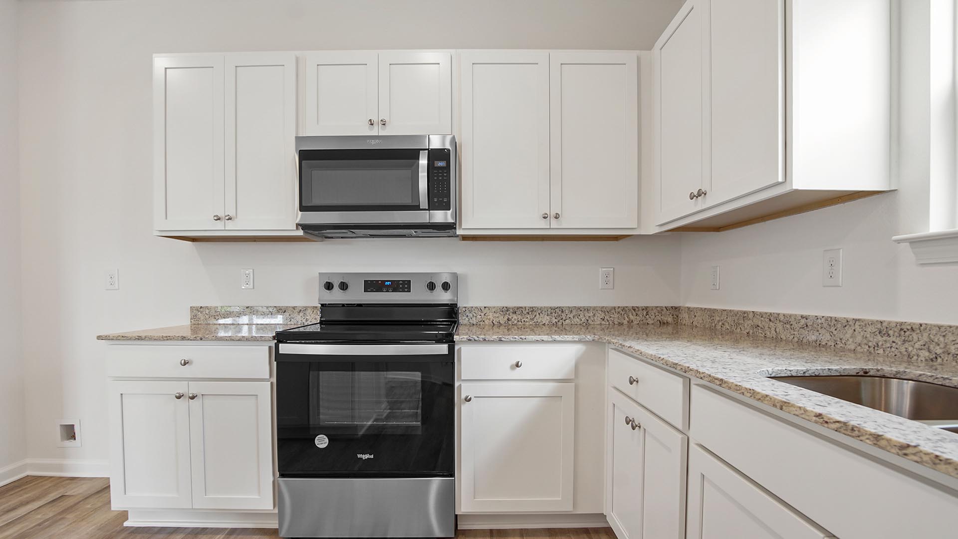 The kitchen is equipped with an appliance package including a smooth top stove, microwave and dishwasher