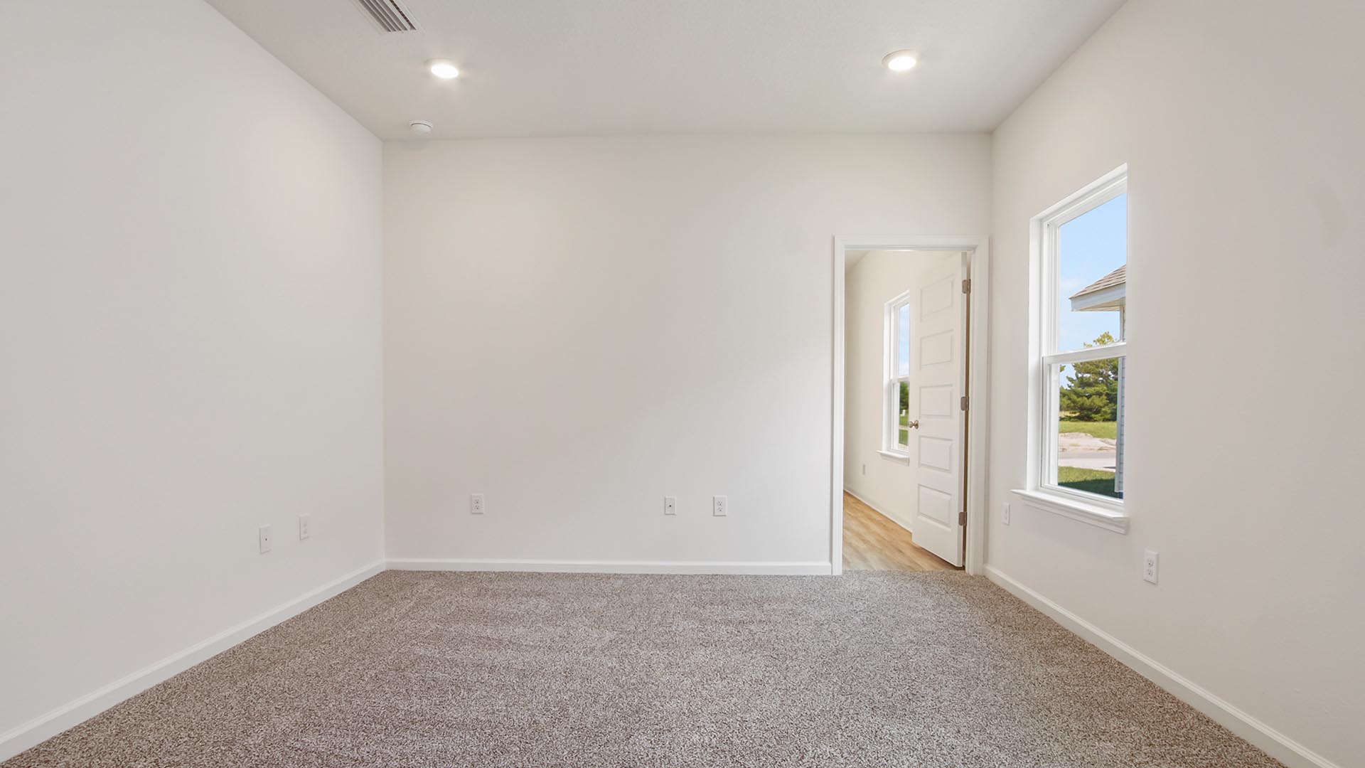 The primary bedroom has carpet plenty of natural light