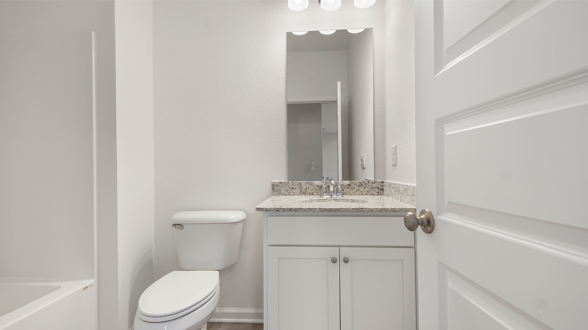 The shared bathroom has a single vanity with granite countertops