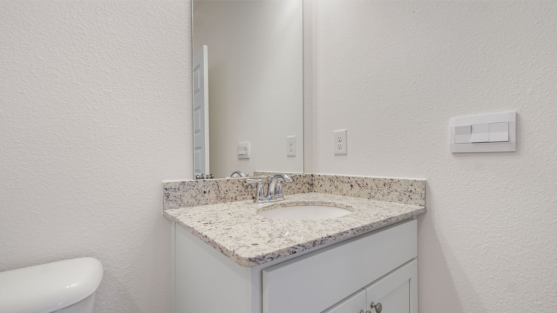 The single vanity has lower cabinetry for storage