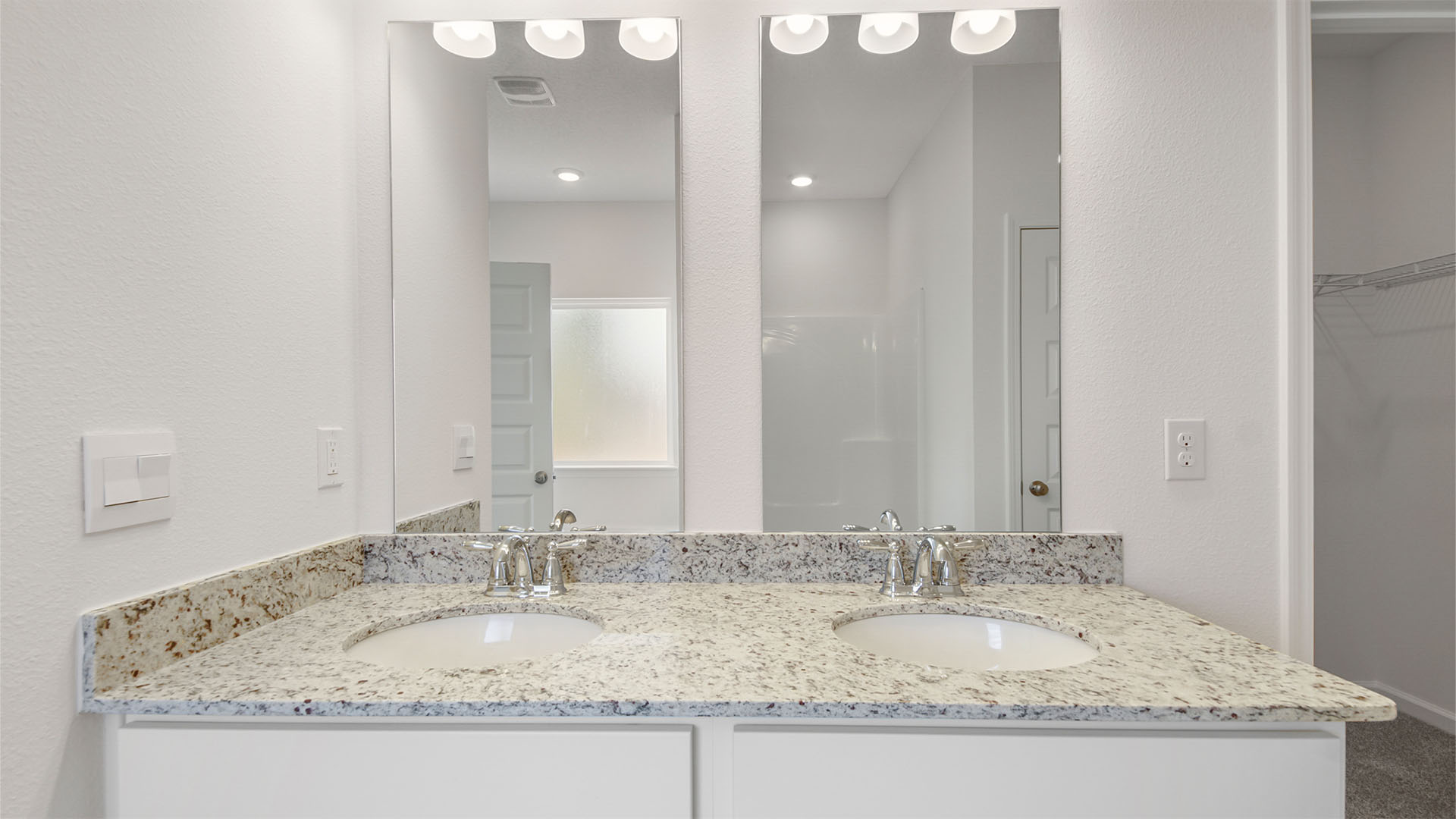 The vanity has granite countertops and lower cabinetry for storage