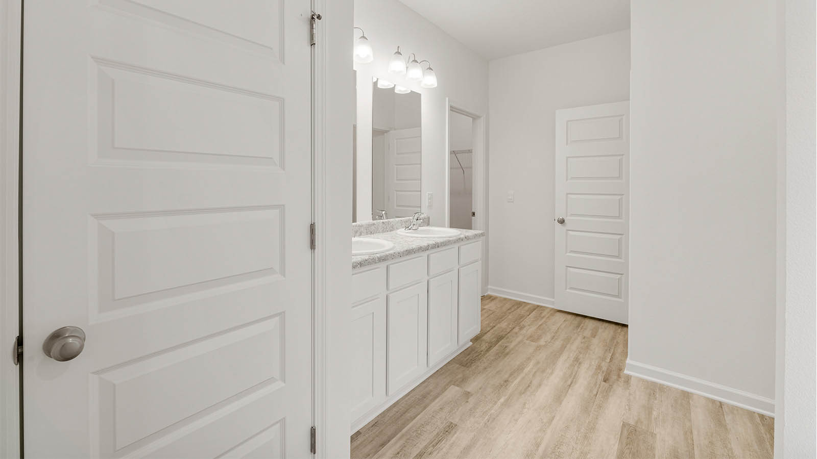 The primary bathroom features EVP flooring with beautiful white cabinetry
