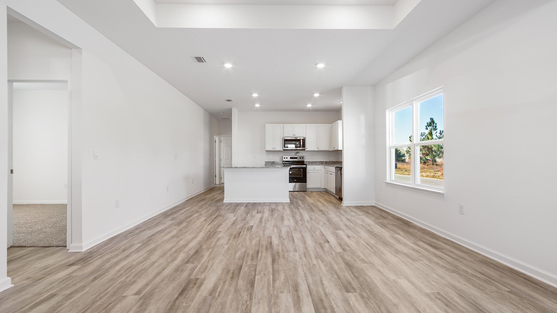 Open concept living area with EVP flooring throughout and granite countertops