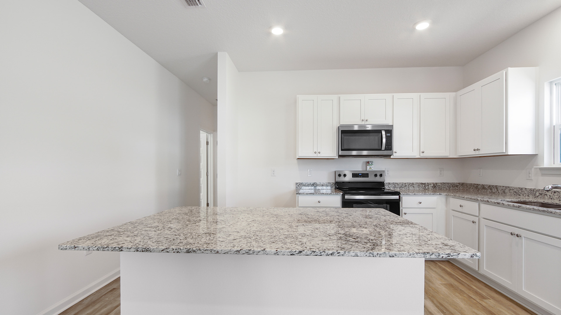 Bedroom four and the laundry room are located of the hall adjacent to the kitchen