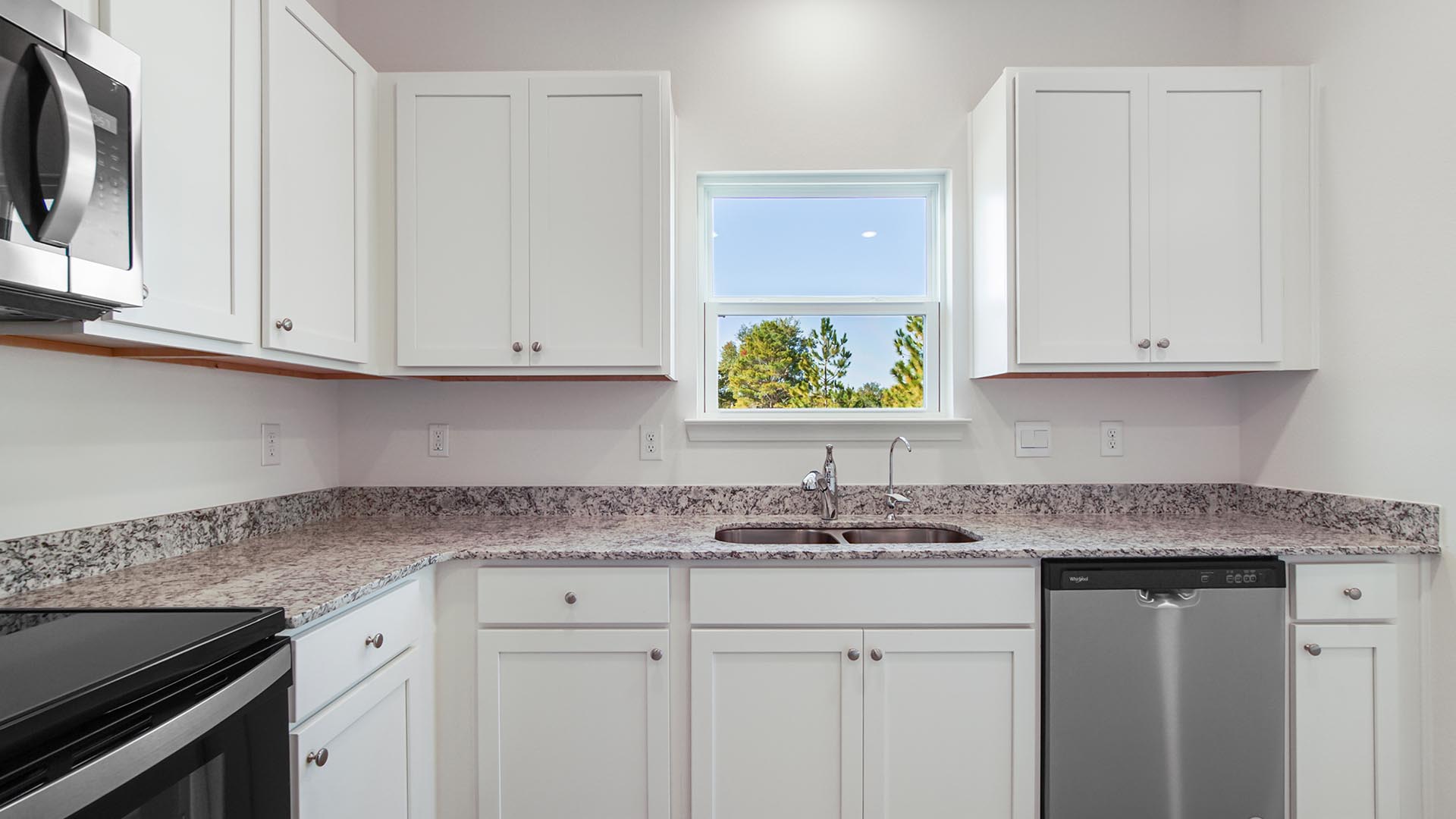 The kitchen features a picture window overlooking the side lawn