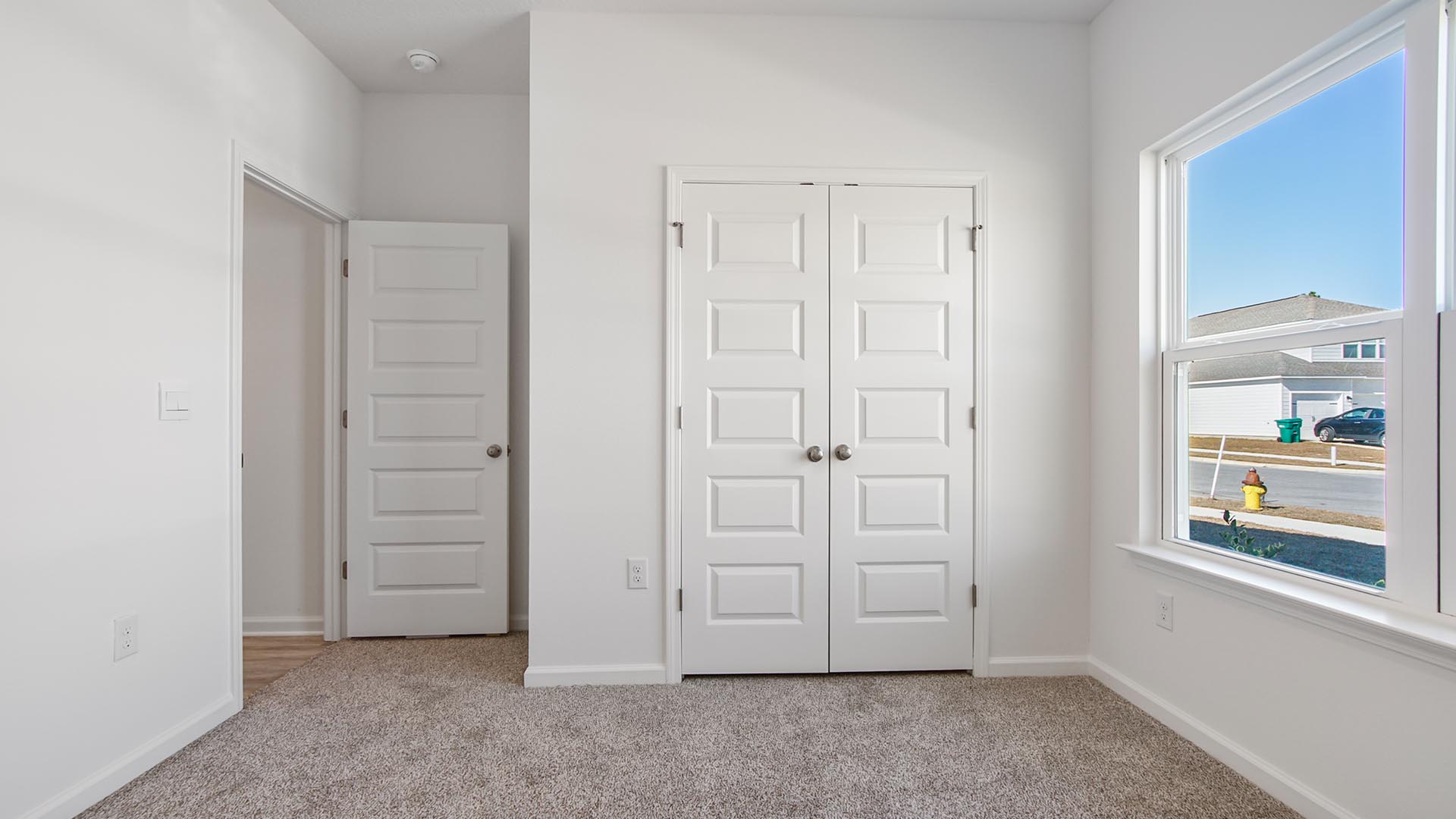 Bedroom three has a large window and features carpet and a spacious closet