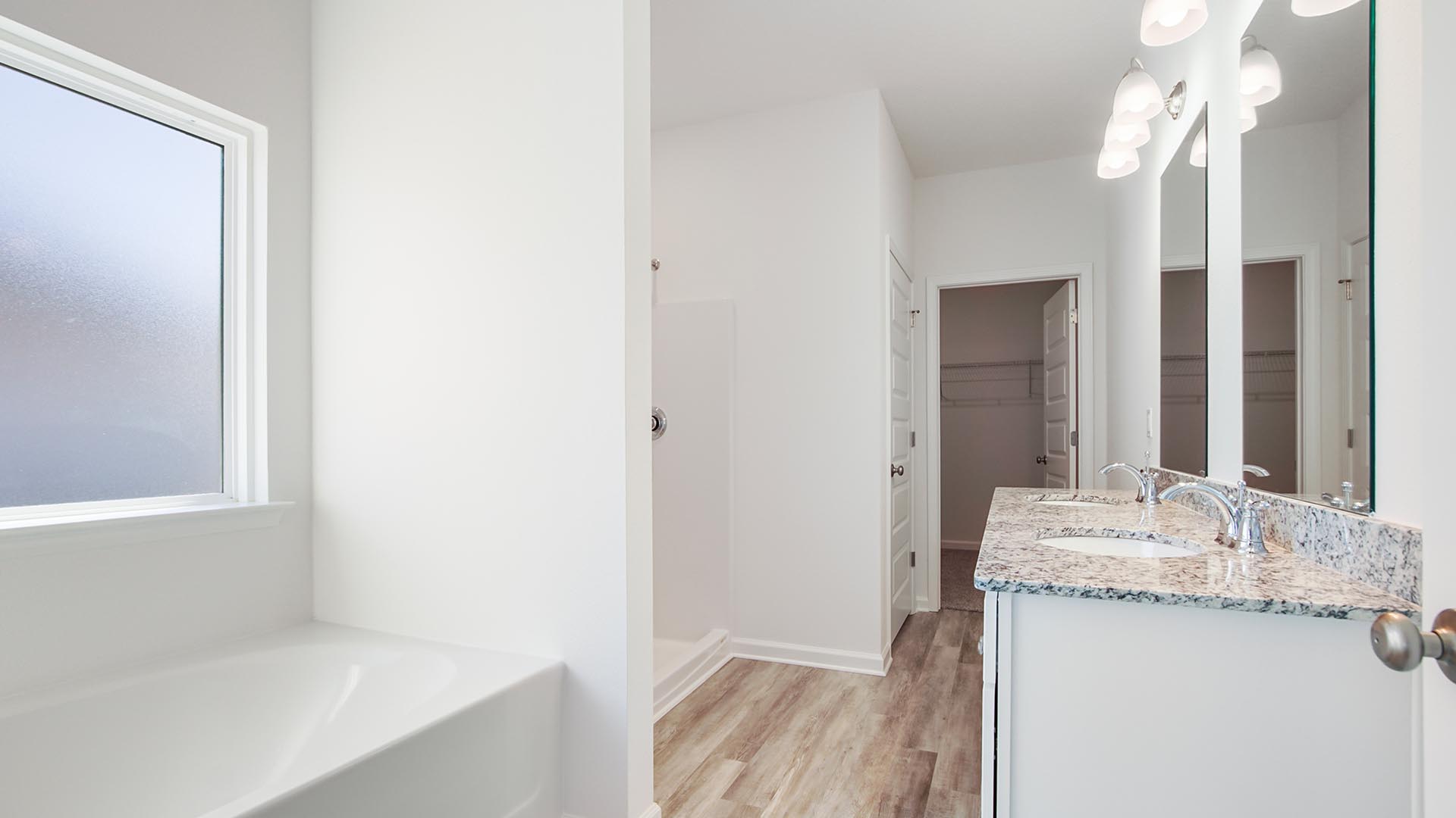 The primary bathroom features a luxurious soak tub and separate shower