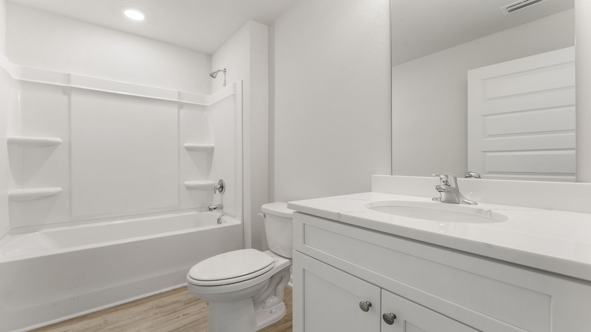 The shared bathroom is between bedrooms two and three. It offers a single vanity with lower cabinetry and quartz countertops