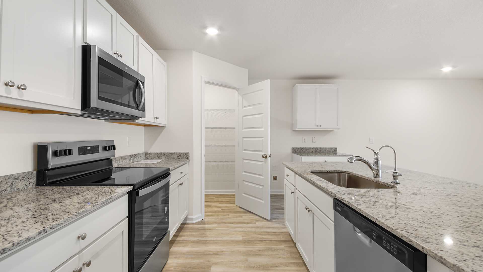 The kitchen has granite countertops and upper and lower cabinetry for storage