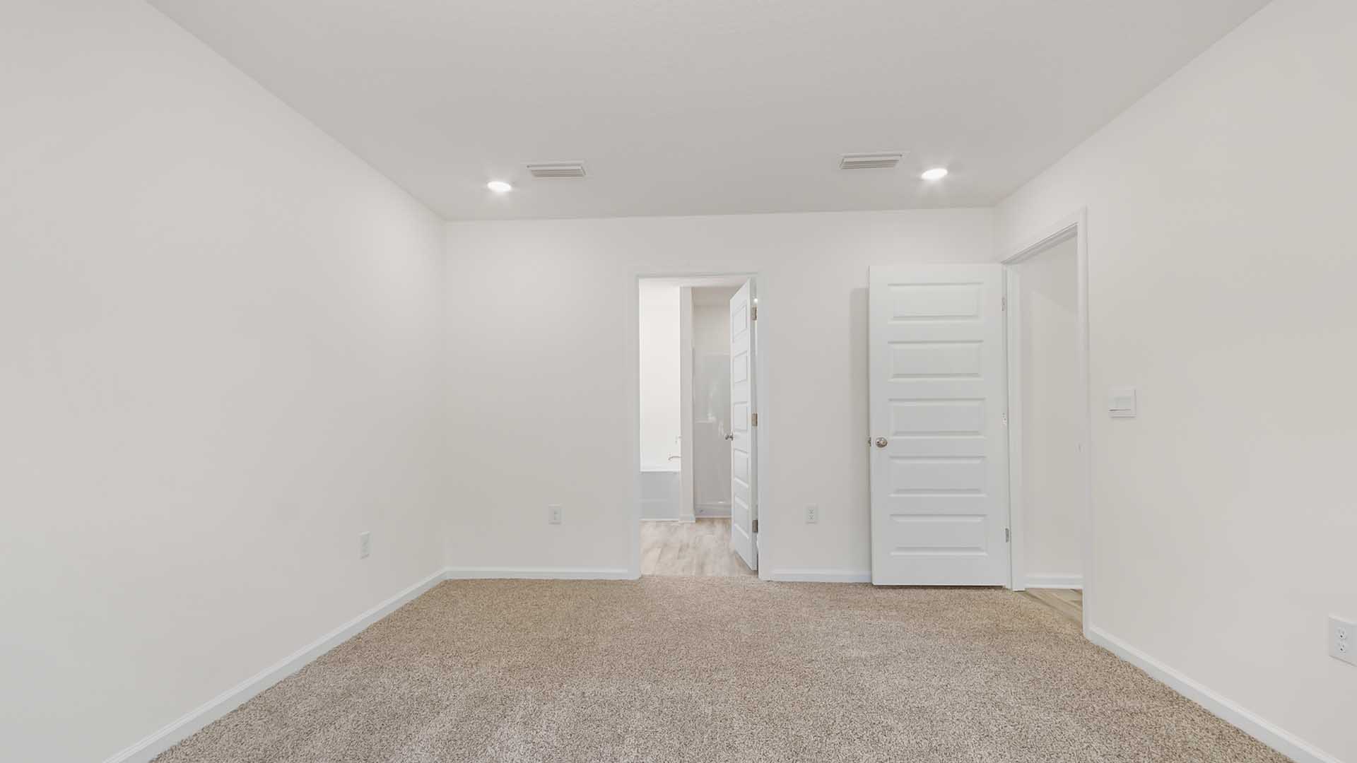 The primary bedroom is spacious and has a private ensuite bathroom