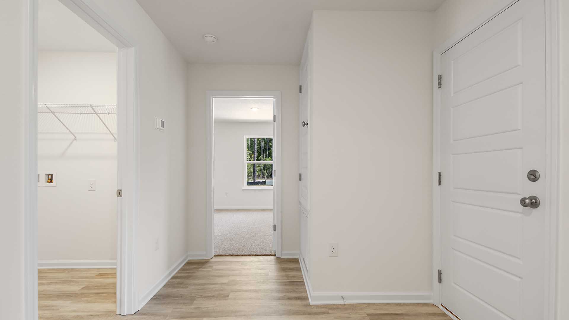 Hall leading to bedroom four has EVP flooring and holds the laundry room