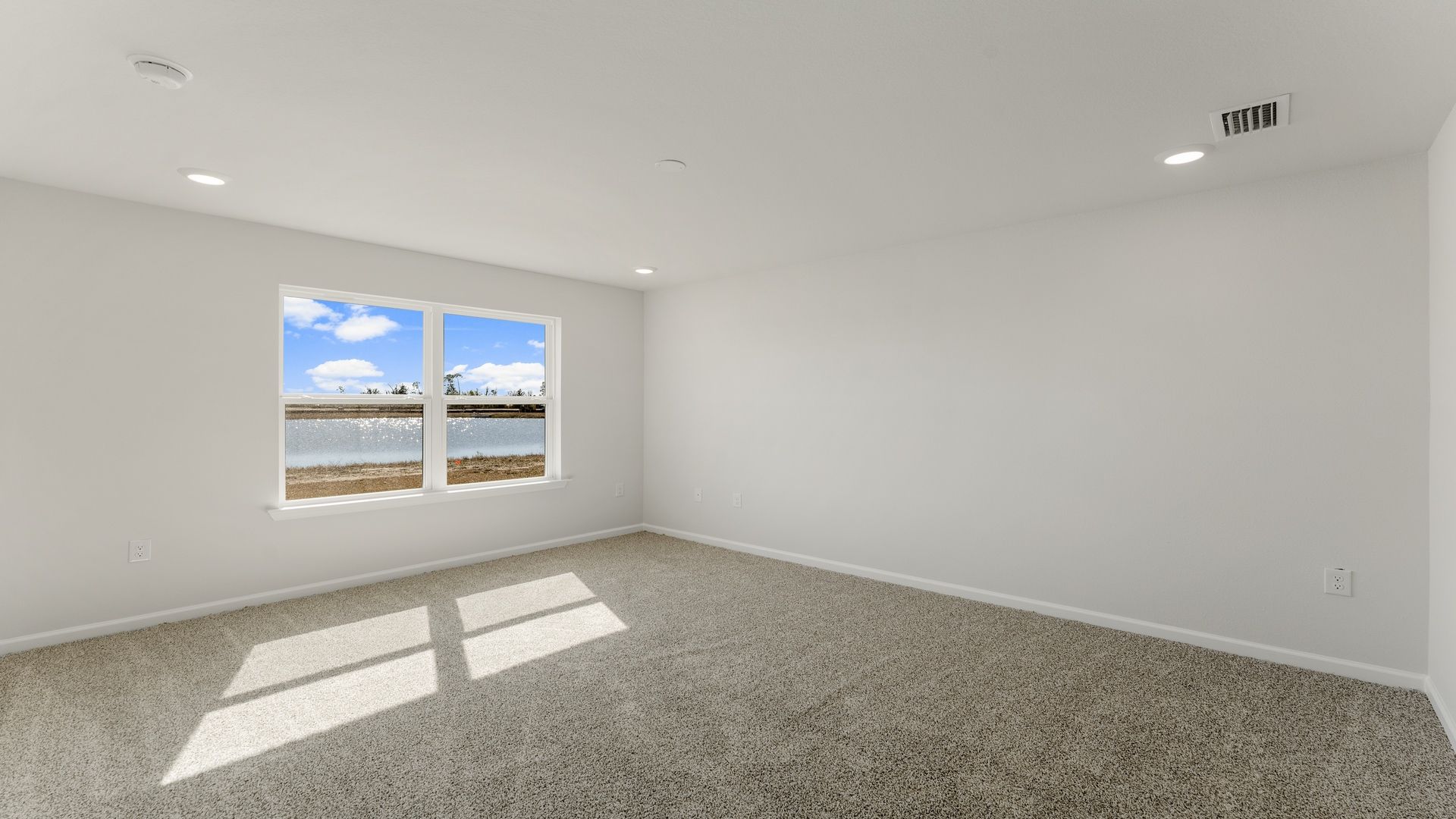 The primary bedroom has a large picture window for natural lighting